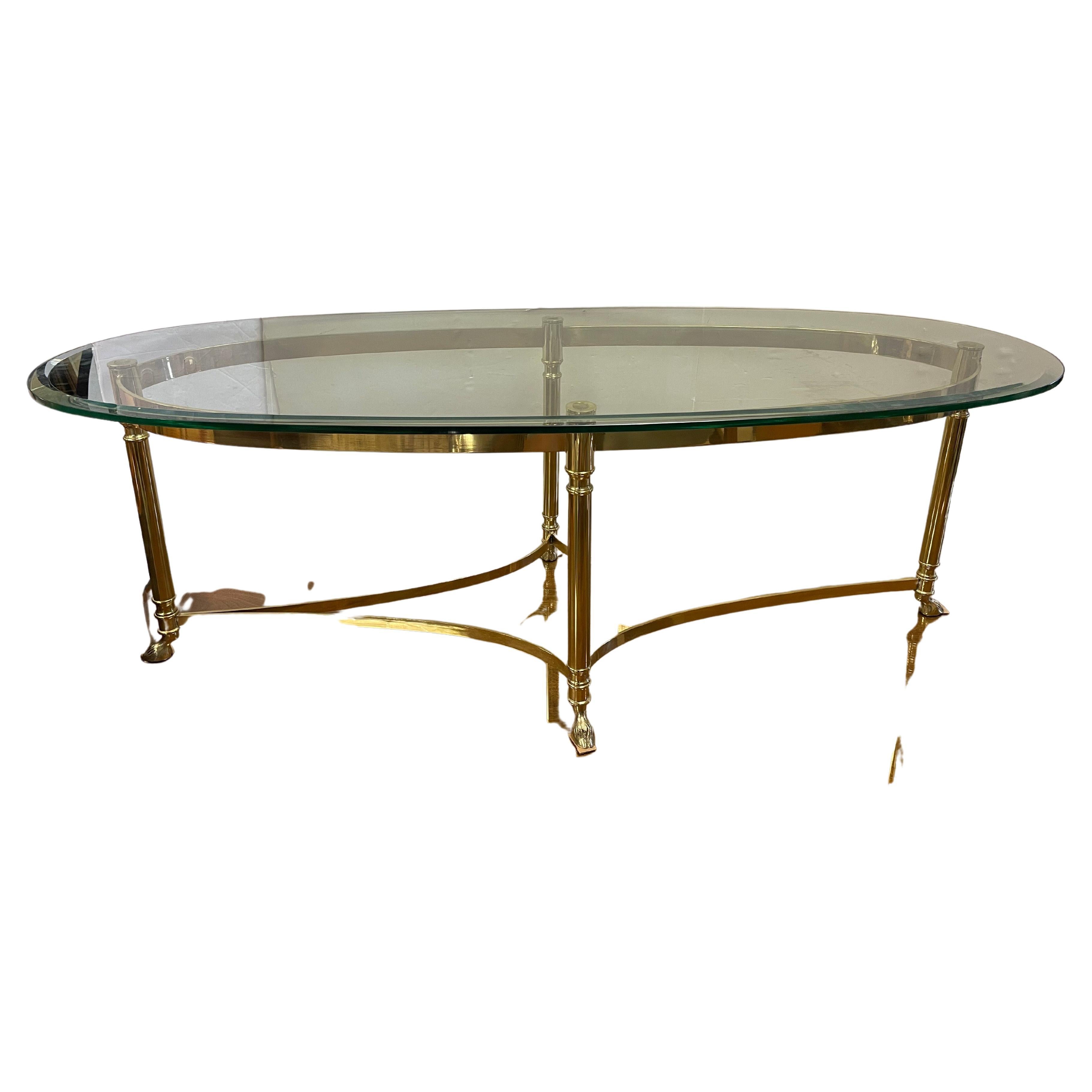 Adorned with a brass base featuring hoof feet, this classic Maison Jansen large oval cocktail table is sure to impress. Note the scale via the dimensions below. Circa 1970s and with lines to die for. Own the best!