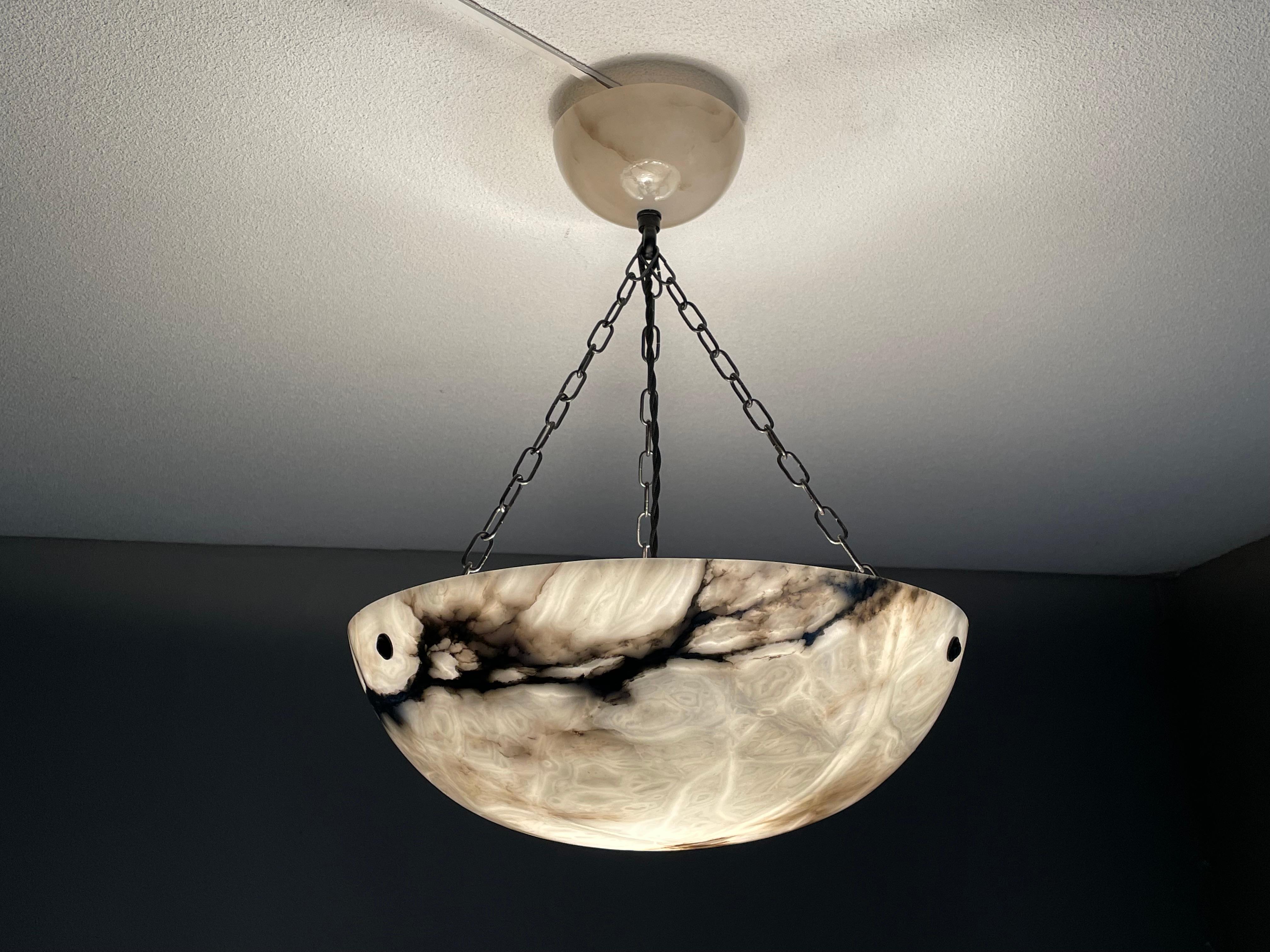 Art Deco chandelier with a good size alabaster shade and a matching design, large alabaster canopy.

Thanks to its good size, its deep bowl shape and its timeless design this alabaster chandelier is bound to light up both your days and evenings. It