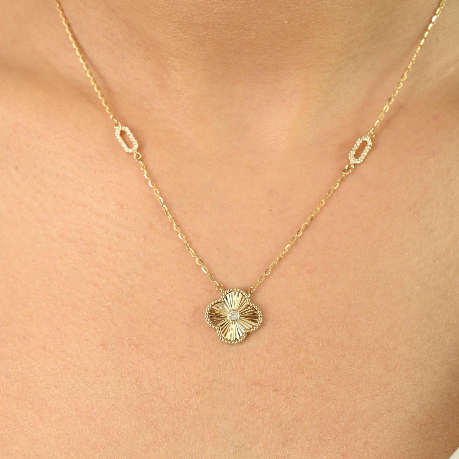 Ce charmant collier en or jaune 14 carats confère à votre décolleté une élégance intemporelle. Doté d'un pendentif en forme de trèfle floral au design délicat et au fini texturé, il est magnifiquement rehaussé d'un diamant étincelant en son centre,