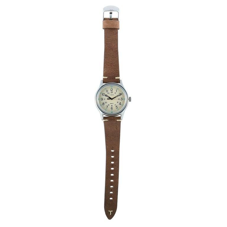 This is the Timex MK1 40 mm, reference number TW2R96800. The watch is presented with a stainless steel case that measures 40 mm in diameter. The beige dial with Arabic numerals features central hours, minutes and seconds. The dial boasts the