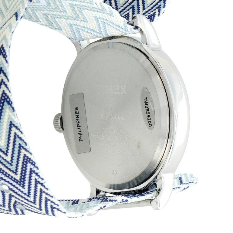This is the Timex Weekender Chevron 38 mm, reference number TW2R59200. The watch is presented with a 38 mm silver-tone brass case that boasts stainless steel back. The case offers water resistance of 30 meters and is mounted onto a multicolor fabric