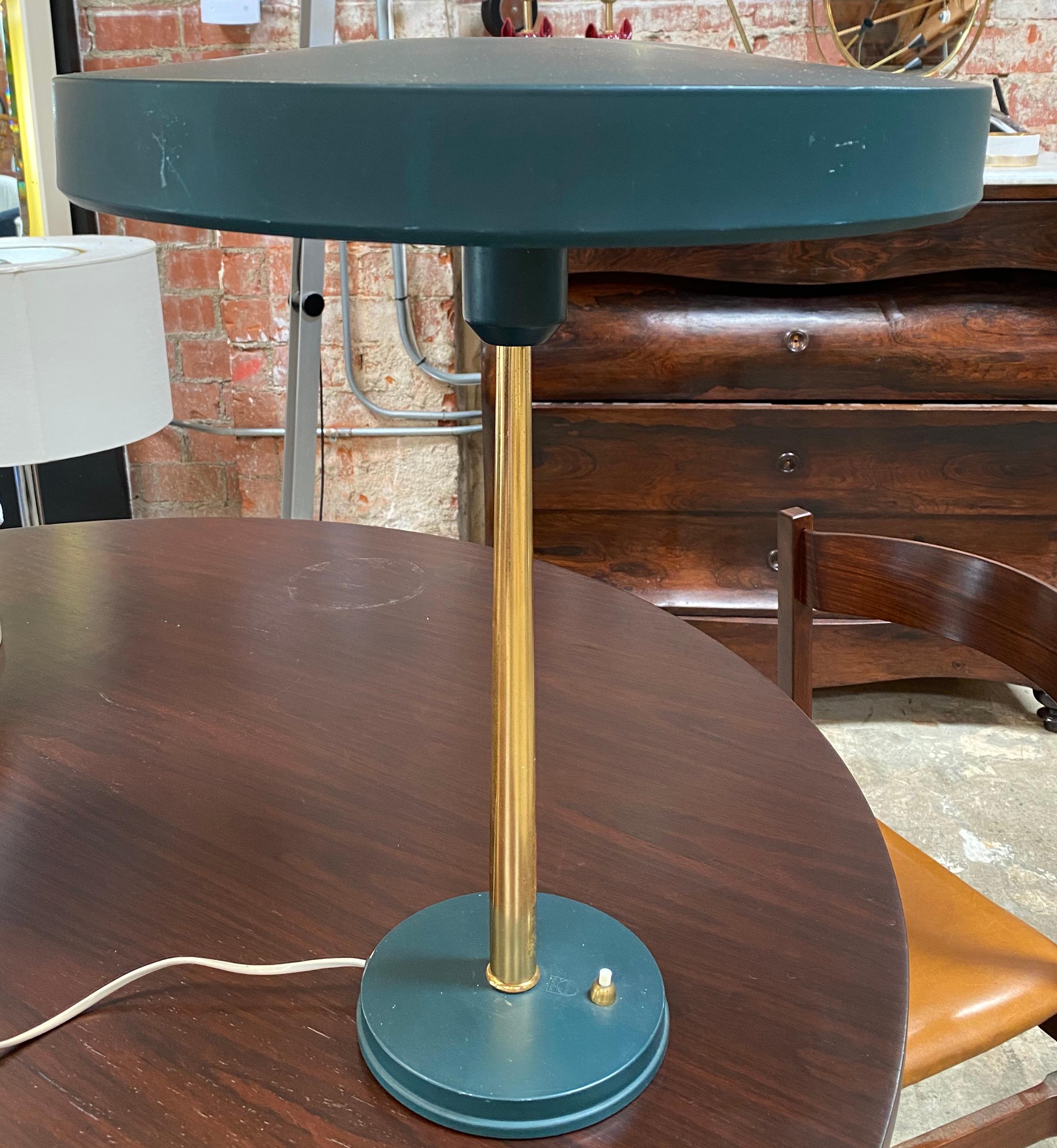 Model Timor desk lamp was designed by Louis Kalff for Philips and it is one of his most famous designs. The lamps features a conically shaped gold steel rod and dark grey painted aluminum base and round screen.
