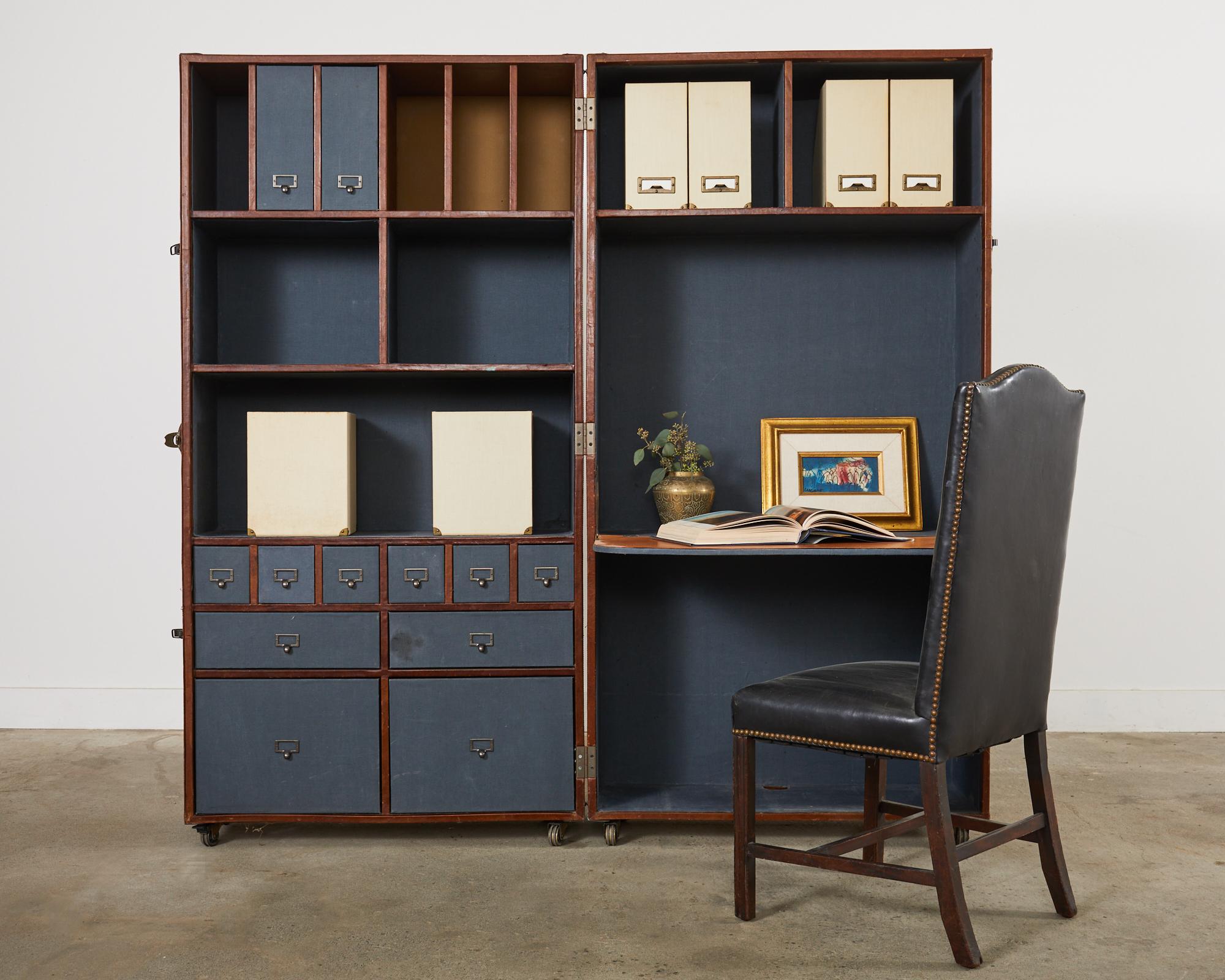 Large campaign style reproduction of an antique steamer trunk that opens to a secretaire with a leather fold (29.5