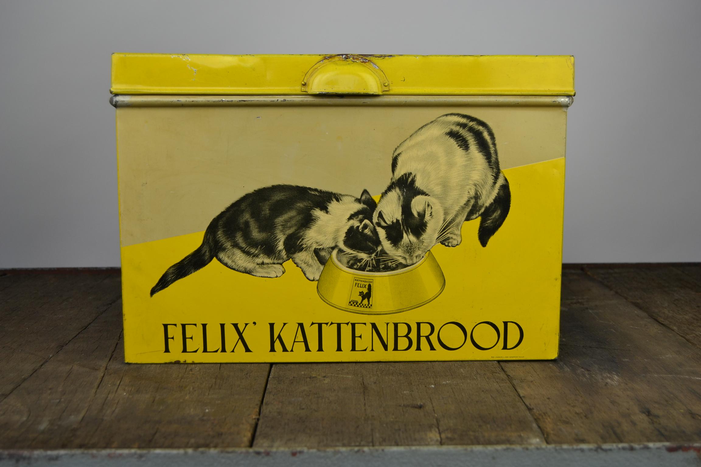 Awesome Tin Box for Cat Food dating  late 1930s - early 1940s. 
This Yellow Tin with Cats was made for the brand : 
Felix Kattenbrood, Pain de Chat Felix, Cat Bread Felix 
by the Dutch Company Wed J. Bekkers & Zoon Dordrecht Holland.
It's a great