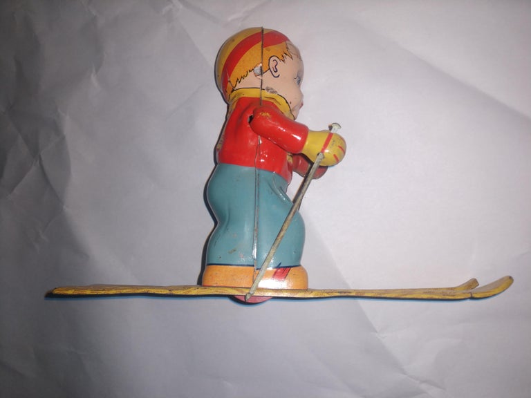 Embossed Mid Century Tin Litho Windup Toy Skier Girl by Chein C1945 For Sale
