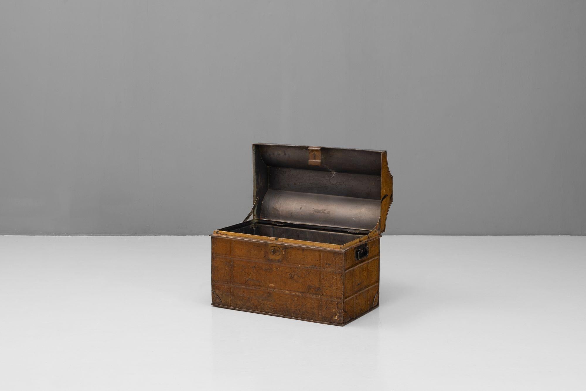 Tin trunk with shaped top and carrying handles in original paint finish. Circa 1900.

H 45cm x W 62cm x D 37cm
