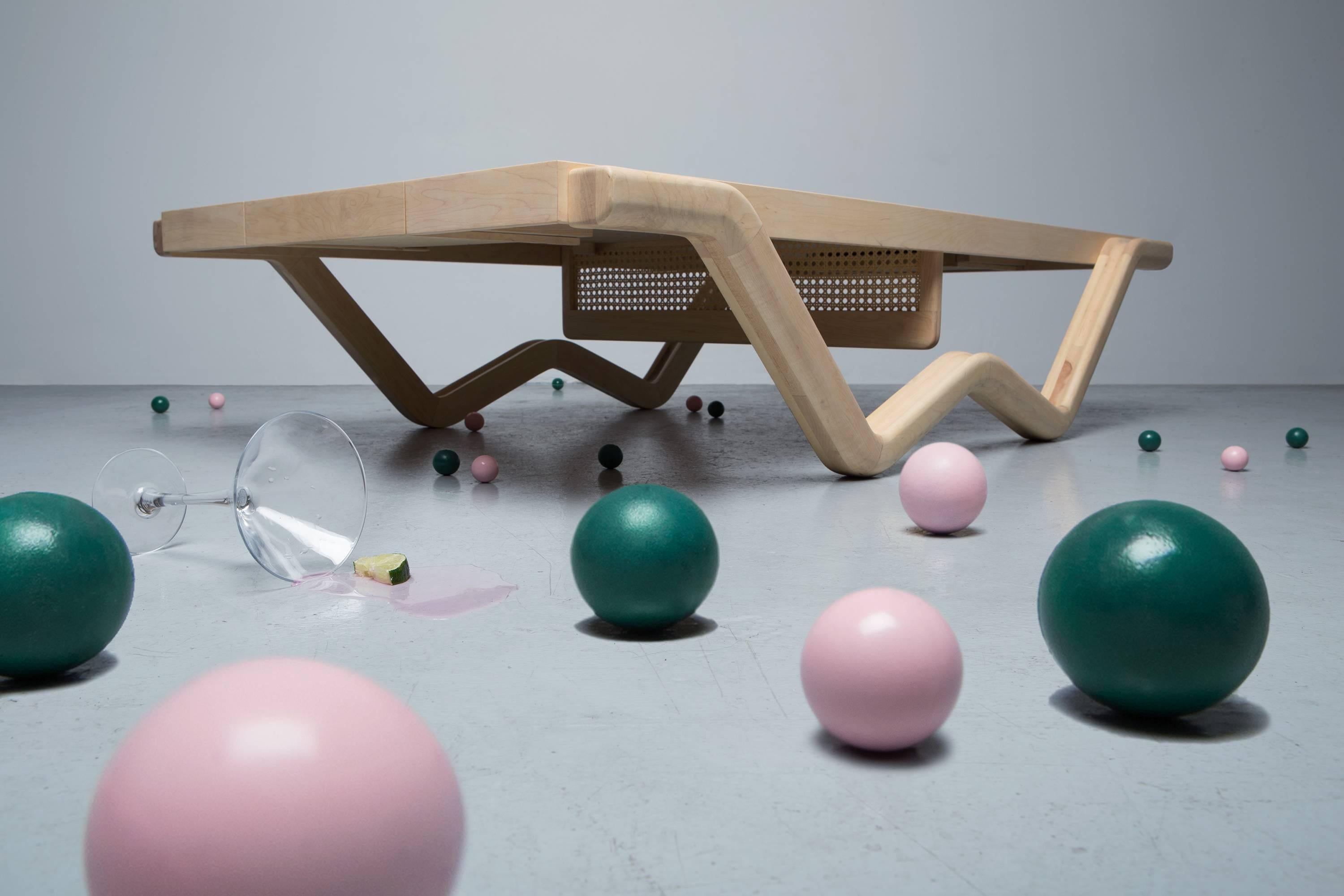 Tina Burner is a refined table that can be used for your afternoon tea or your morning match. Its playful design transforms into a ping pong table. Open the drawer and grab a racket, let’s play! Its rattan net has two positions and once set up, it