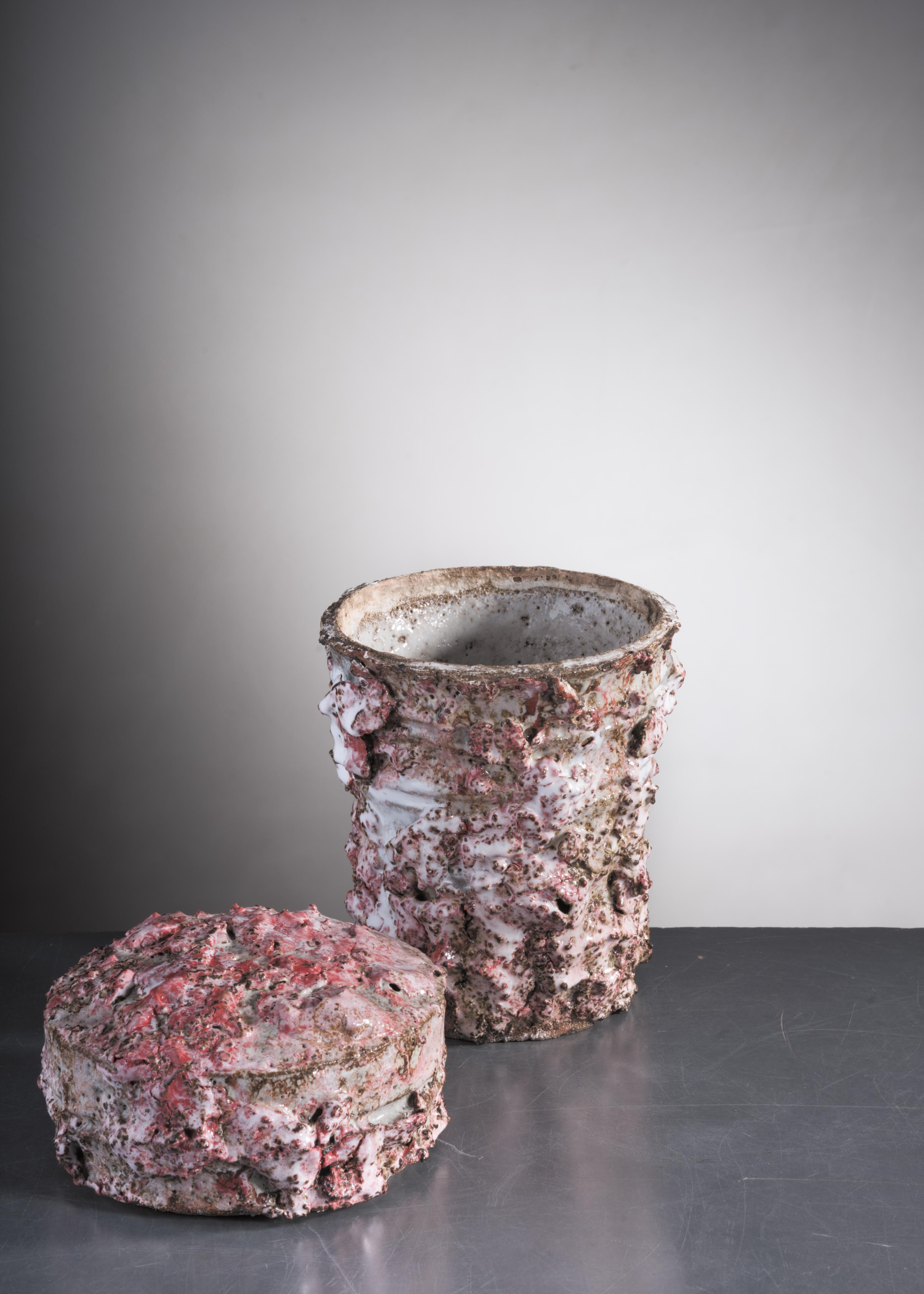 A jar with lid by Danish ceramist Tina Langhoff (1971). It is made of stoneware and porcelain with a thick, textured pink and white glazing.