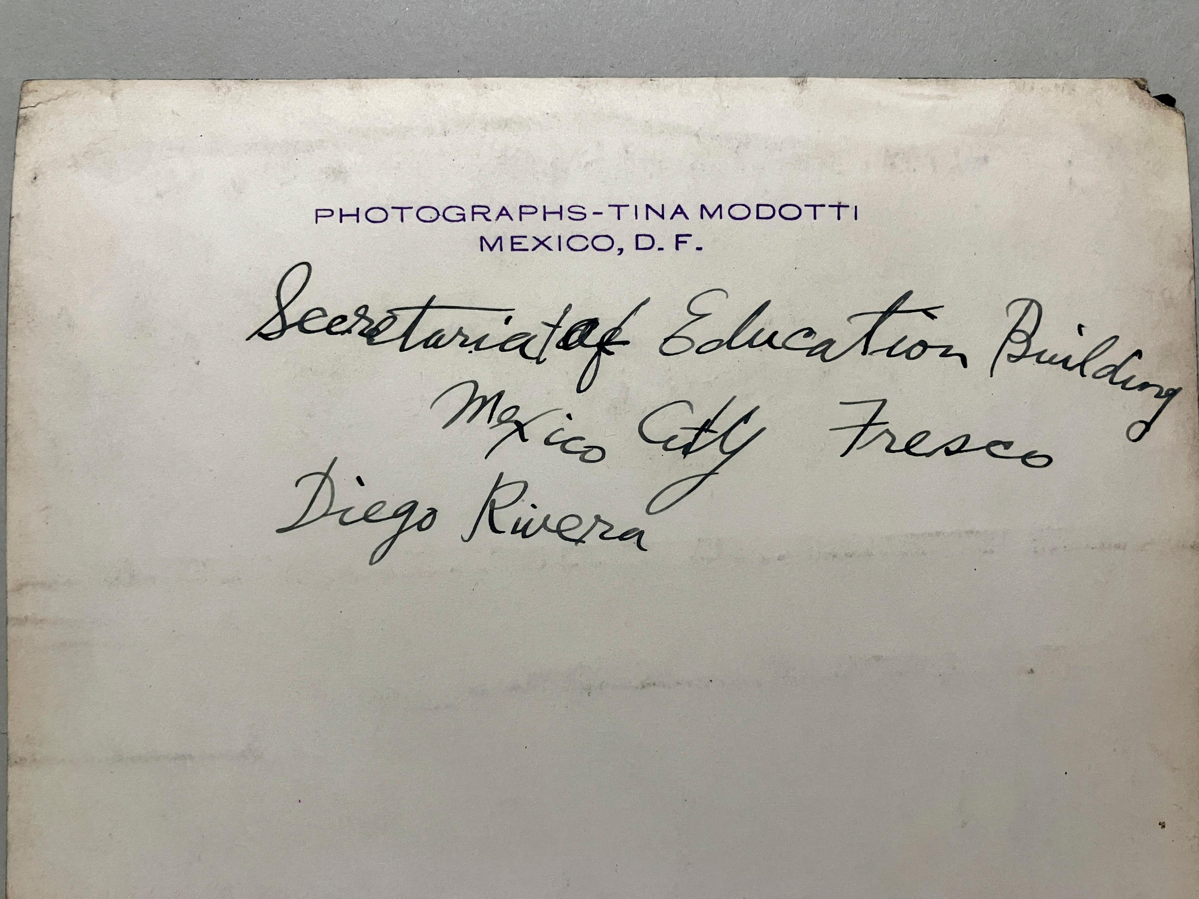 An original 1920s silver gelatin print by photographer Tina Modotti, that shows a fresco in the Secretariat of Education Buiilding, Mexico City that illustrates a popular ballad.  Photo is stamped “Photographs-Tina Modotti Mexico, D.F.” on reverse. 