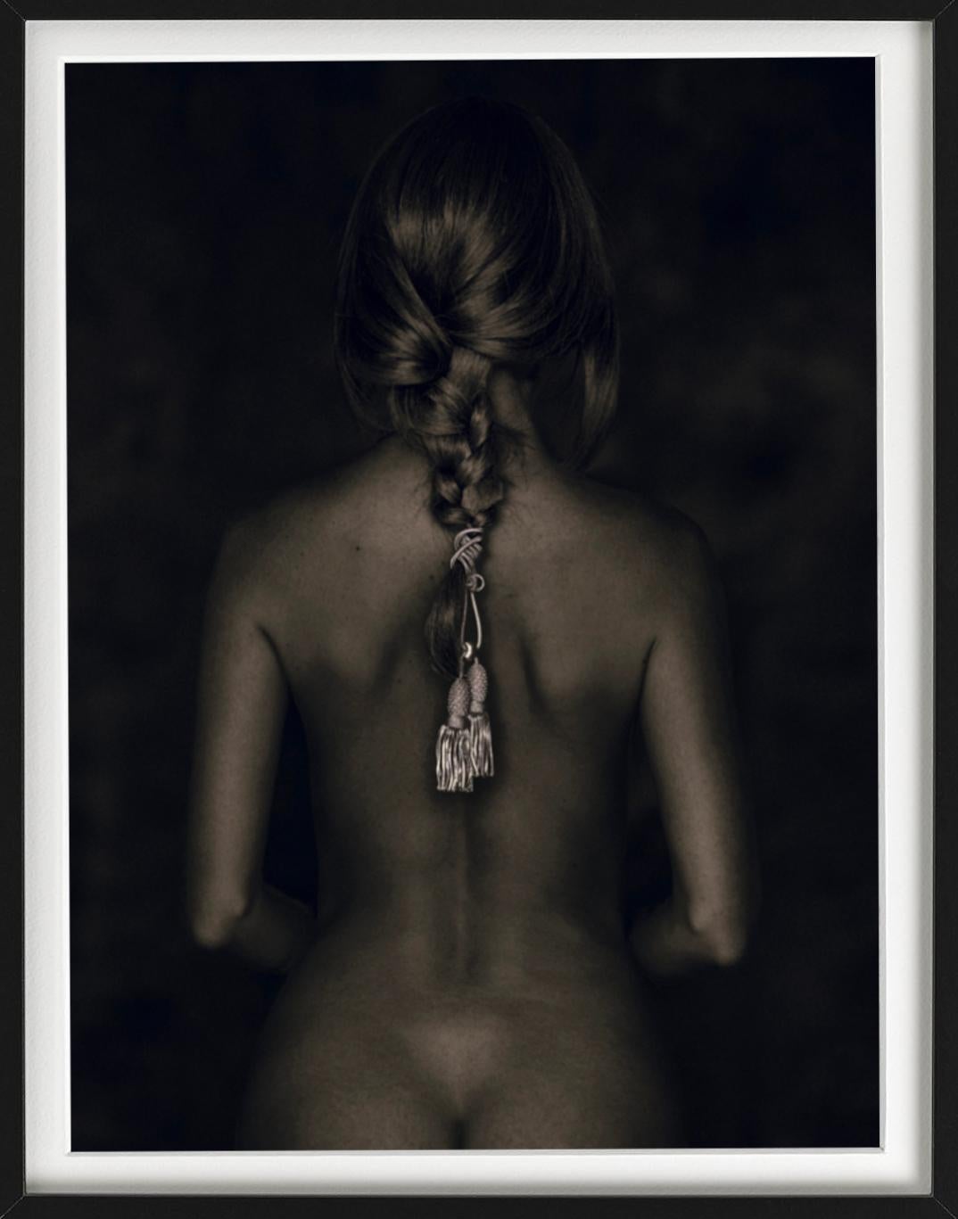Nu de Dos - female nude from behind with cord in braided hari sitting - Black Color Photograph by Tina Trumpp