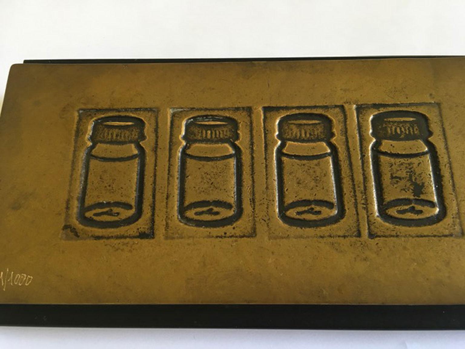 This is a multiple bronze with wood base create by the Italian artist Tino Stefanoni in 1980 circa.
This artwork is following Pop Art and its philosophy that elevates everyday objetcs to art. In this piece the artist doesn't uses the real objects