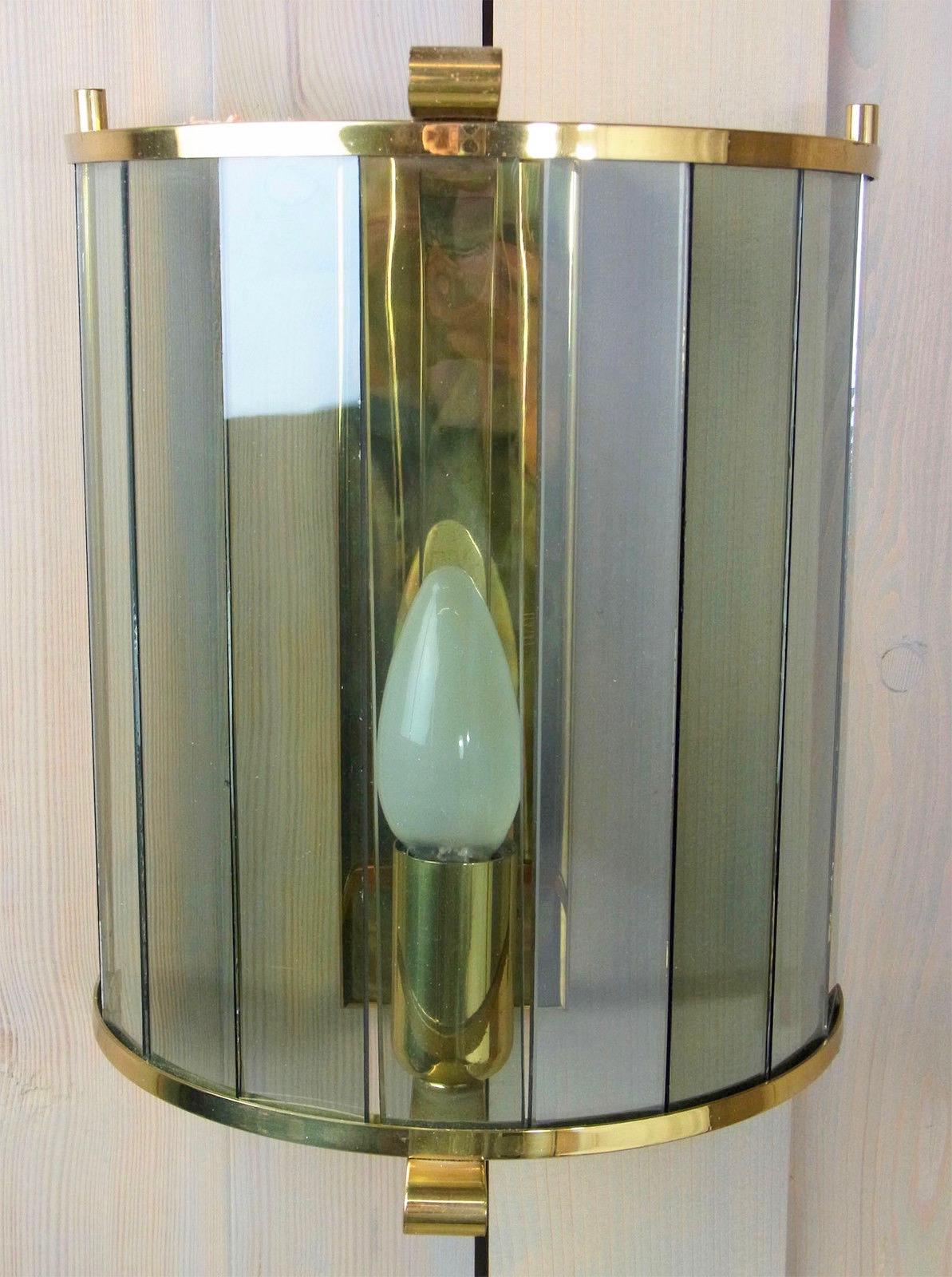 Elegant German Mid-Century Modern wall light with tinted glass panes in a brass base. Manufactured in Germany. This fixture requires one European E14 candelabra bulb, up to 60 watts.