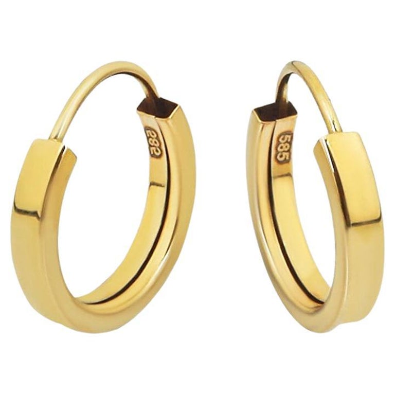 Tiny Huggie Hoop Earrings in 14 karat yellow gold. Huggie hoop gold earrings. For Sale