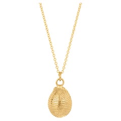 Winzige Kaurimuschel-Halskette aus massivem Gold am Meeresufer