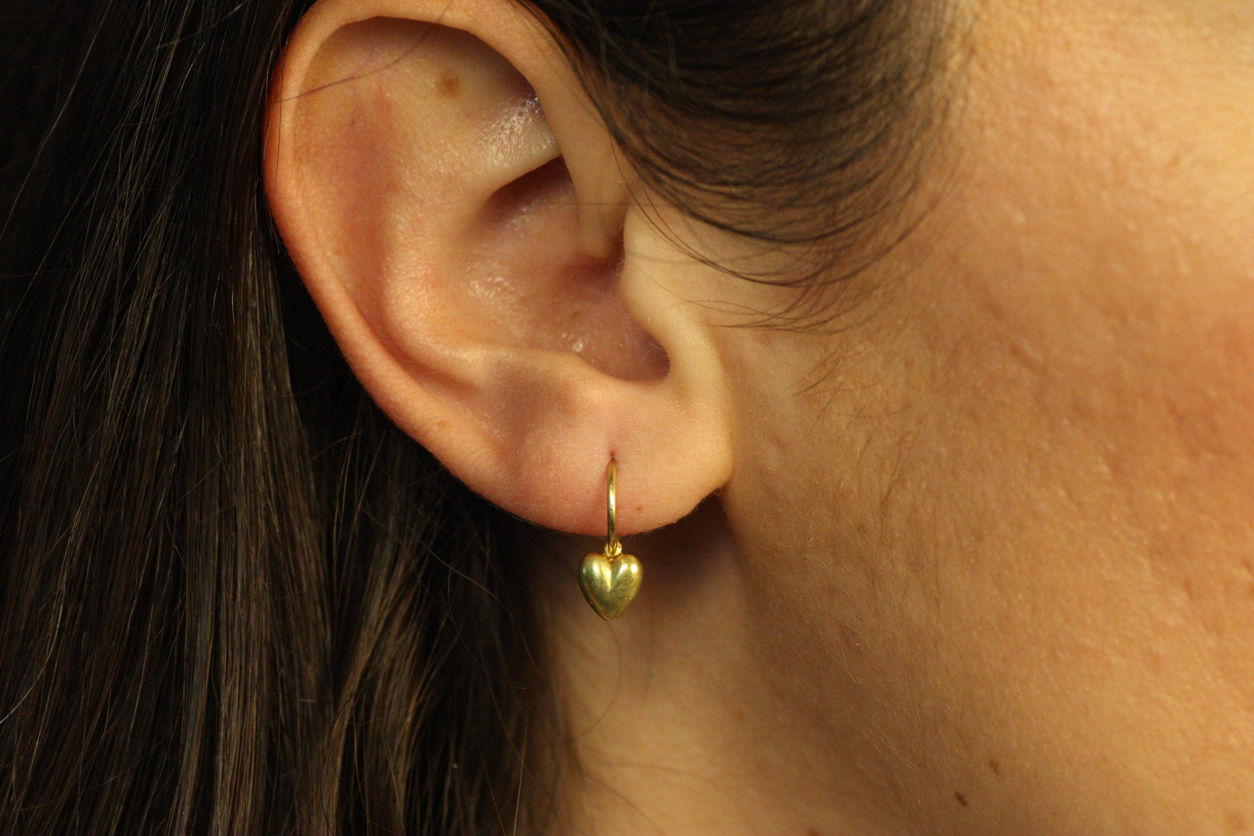 These delicate 20K California gold Tiny Heart Earrings are a subtle yet beautiful expression of love. The solid gold hearts dangle gently from handcrafted gold wires, adding a touch of understated elegance to any outfit. These earrings are perfect