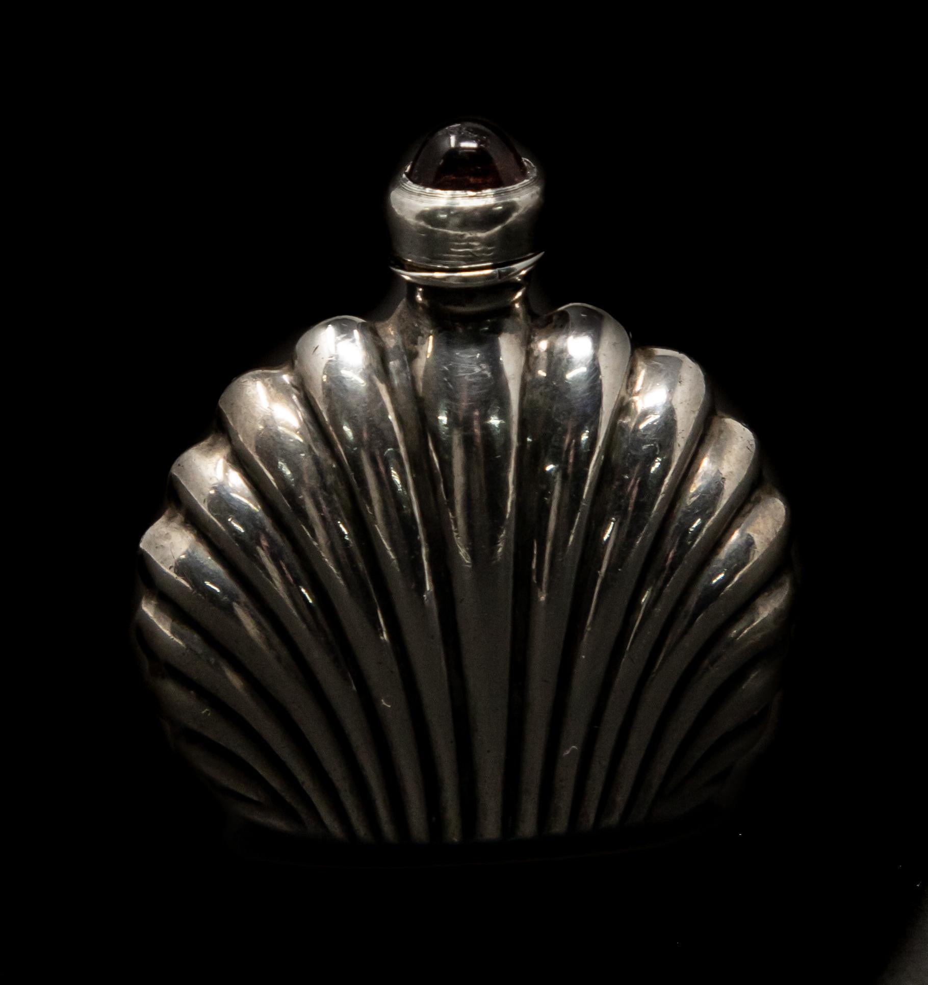 This Art Deco sterling silver perfume bottle is a gorgeous piece. Has a amethyst colored stone on the top. The dipper is threaded so you can open and close.