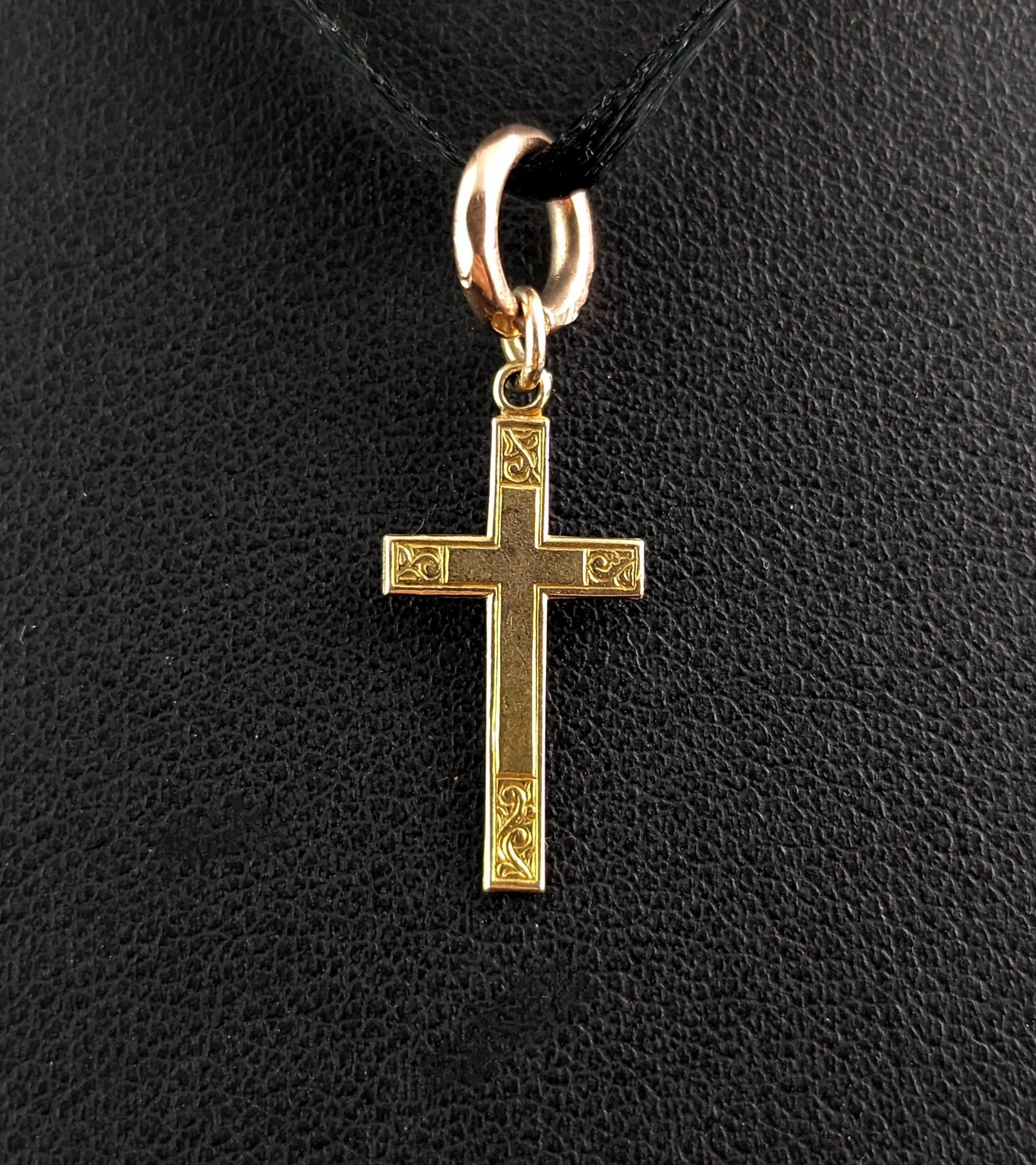 The sweetest tiny little 9ct gold cross pendant or charm.

It is a small sized piece with a fine line engraved border and detailed engraved corners with an almost Celtic design of swirling flora.

The charm is a mid-century piece and is hallmarked