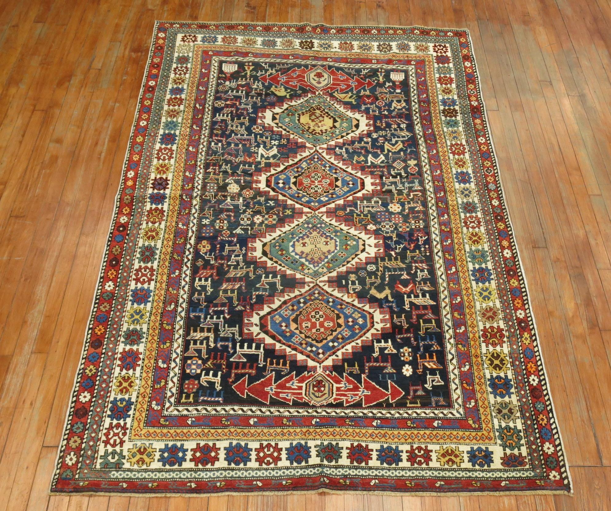 A colorful antique Shirvan rug woven in the Caucasian mountainous region. Running birds running through medium blue ground with 2 green and 2 blue geometric medallions surrounded by multiple borders.