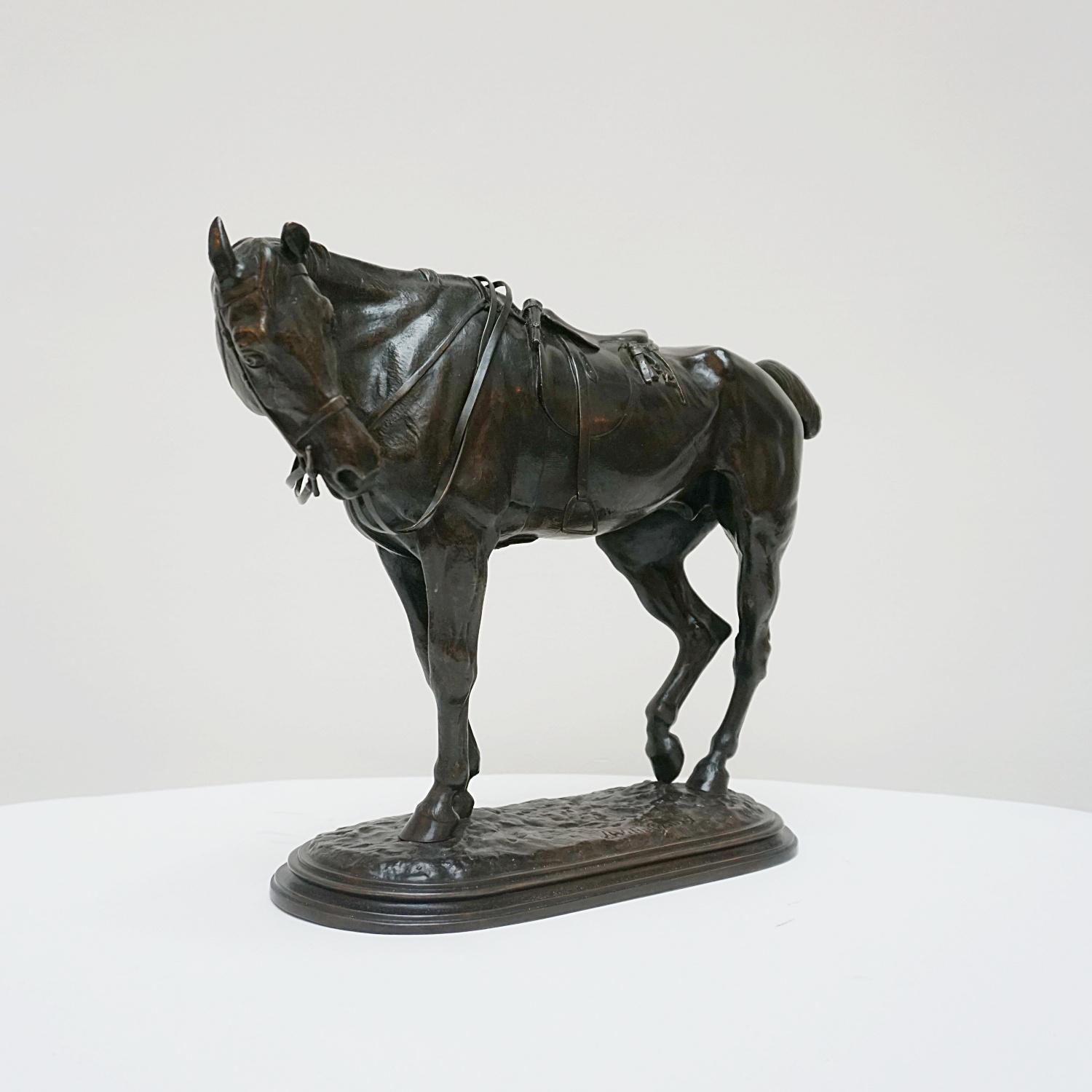 An excellent late 19th century English Animalier bronze study of a tried hunter in full tack taking a break with his neck turned and back leg rested. The bronze exhibits a wonderful rich brown patina, raised on a naturalistic oval base, signed J