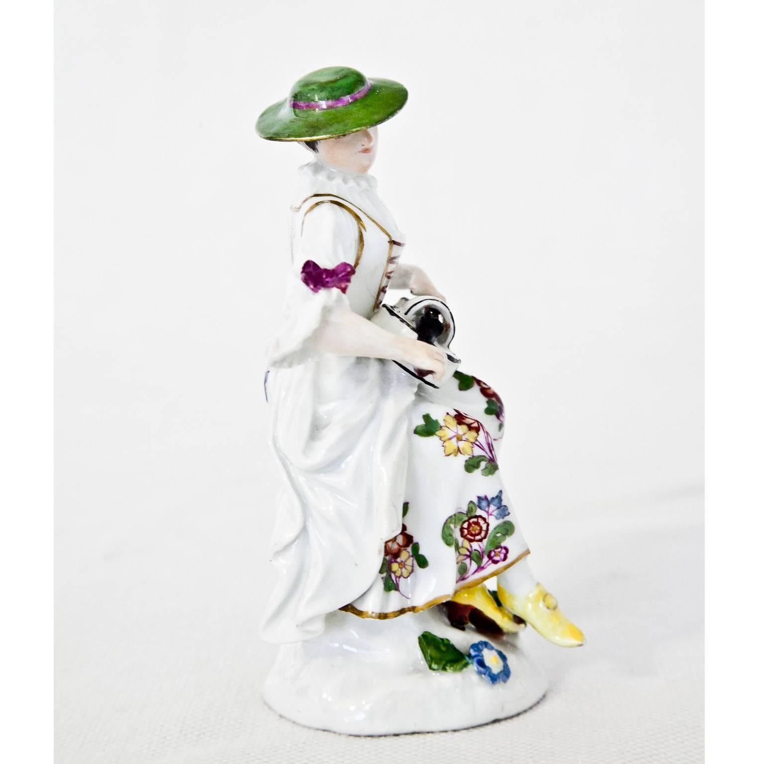 Polychrome painted porcelain figurine of a Tirolean lady playing the zither. Blue swords mark on the bottom.
