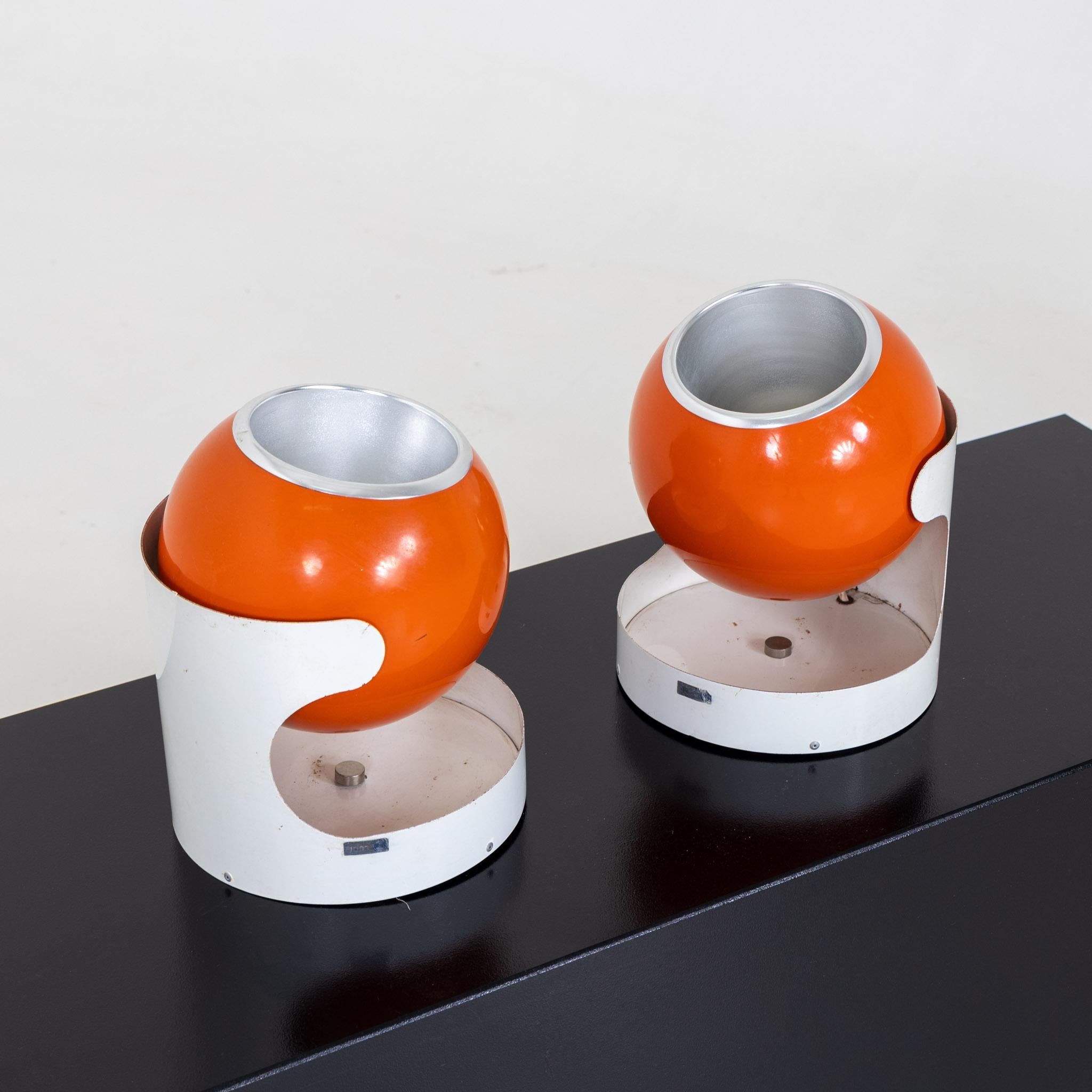 Pair of table lamps on white stands with spherical orange bodies. Label on the side 