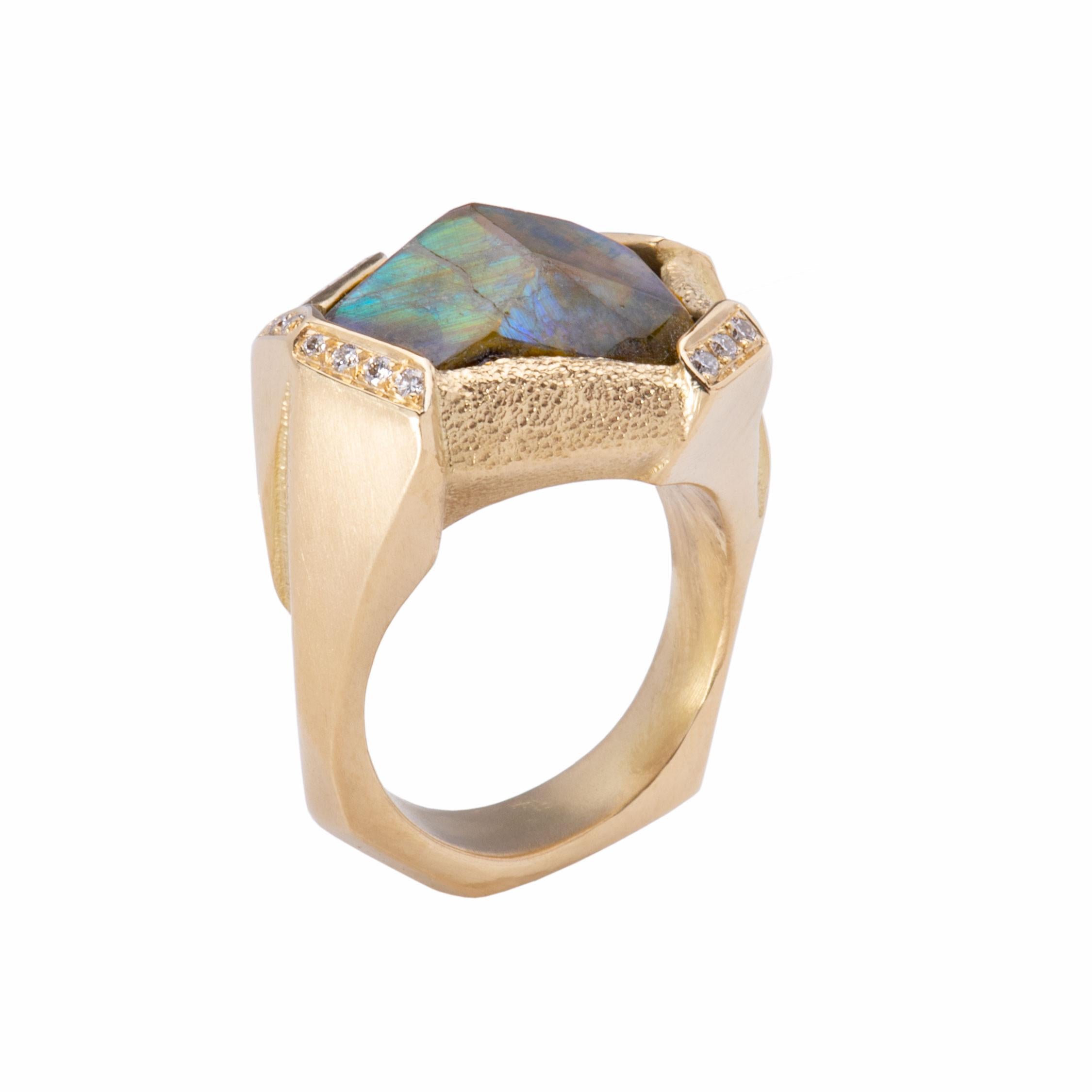 An iridescent andradite garnet 15cts is edged with brilliant white diamonds .23cts and set in 18k gold. An asymmetrical setting composed of satin and stippled gold adds to the style appeal of this extraordinary ring. Hand crafted, this dramatic, eye