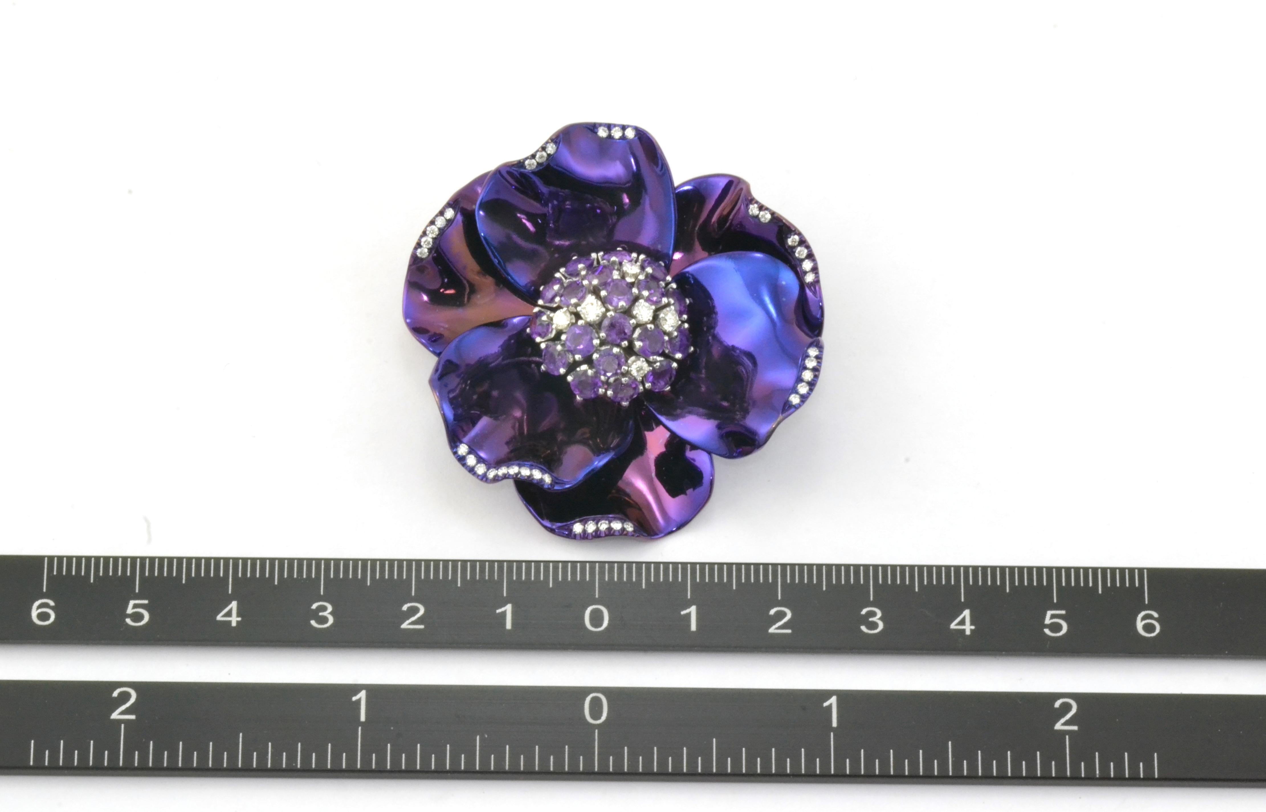 A very decorative brooch in light polished purple titanium, handcrafted in Margherita Burgener workshop, Valenza, Italy.
Some little diamonds are set to highlight the border of the petals, while the center of the brooch has a spray in 18 Kt white