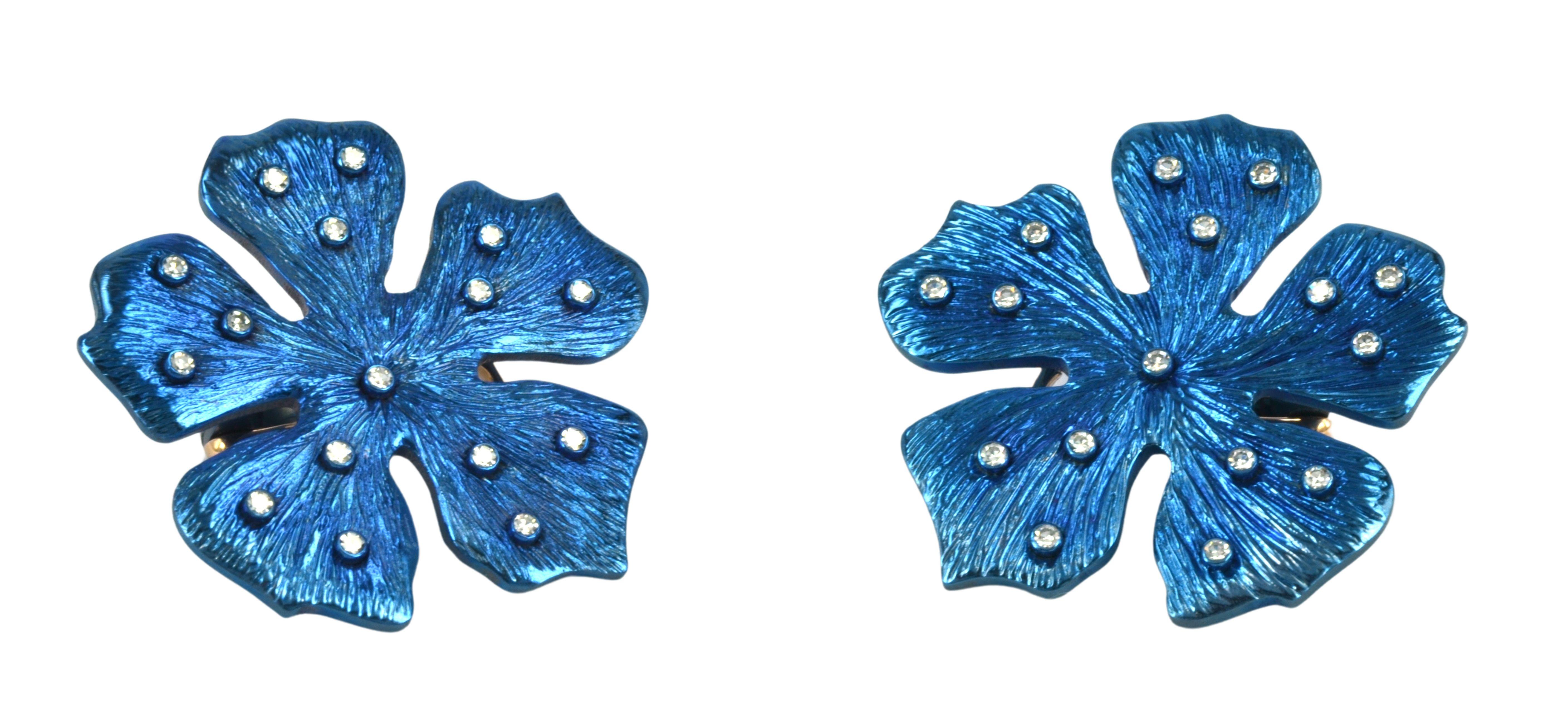 Un par de pendientes bidimensionales en versión Flor Feliz, hechos a mano en el taller de Margherita Burgener.  
Gracias al titanio son extremadamente ligeras. 
Titanio oxidado en color azul claro.  El color es estable. 
Bajo pedido, pueden ser sólo