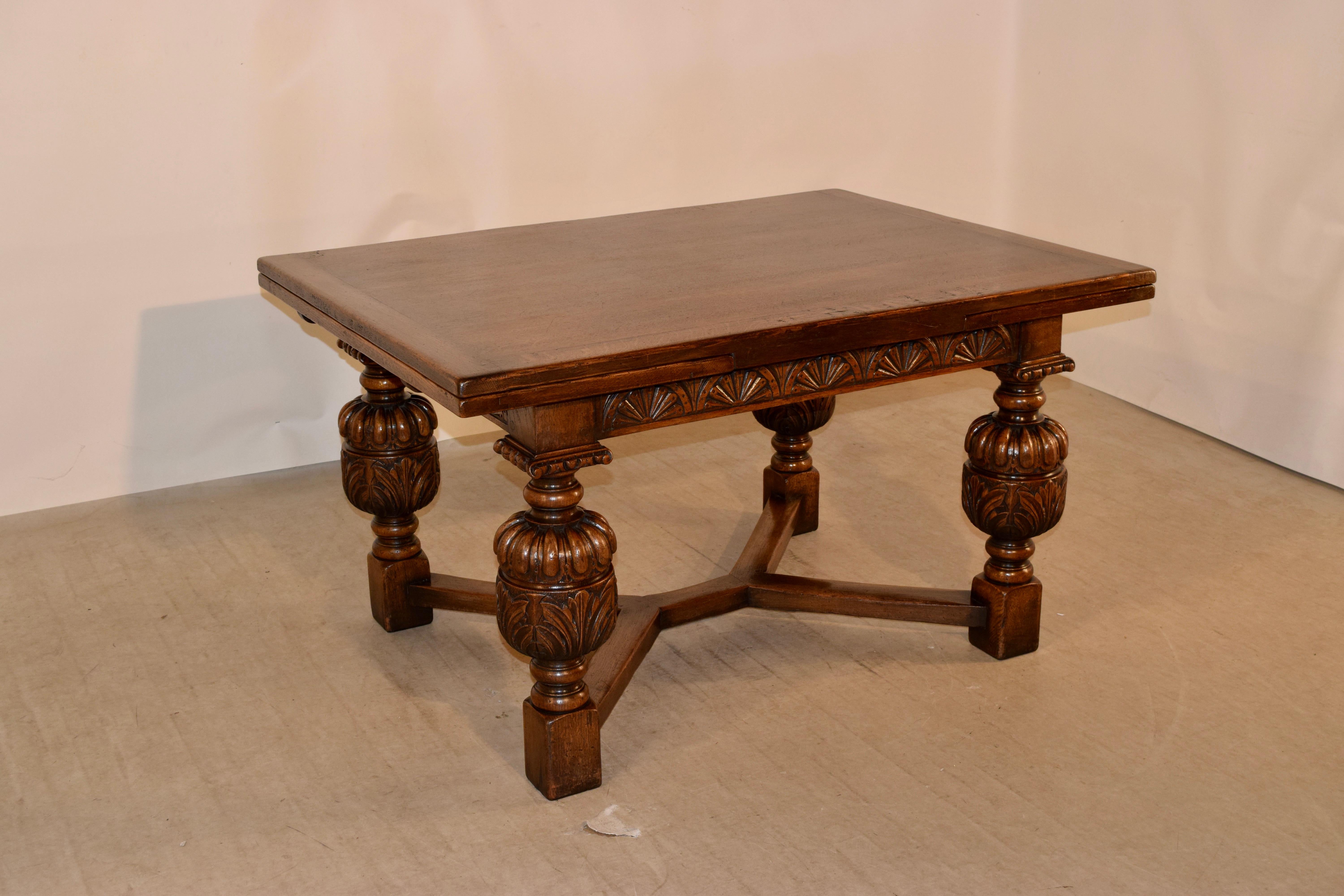 Late 19th century oak table by the very well-known Titchmarsh and Goodwin Company in Ipswich. The top is banded and has two draw leaves, which measure 89.38 inches when open. The apron is wonderfully hand carved decorated, and the table is supported