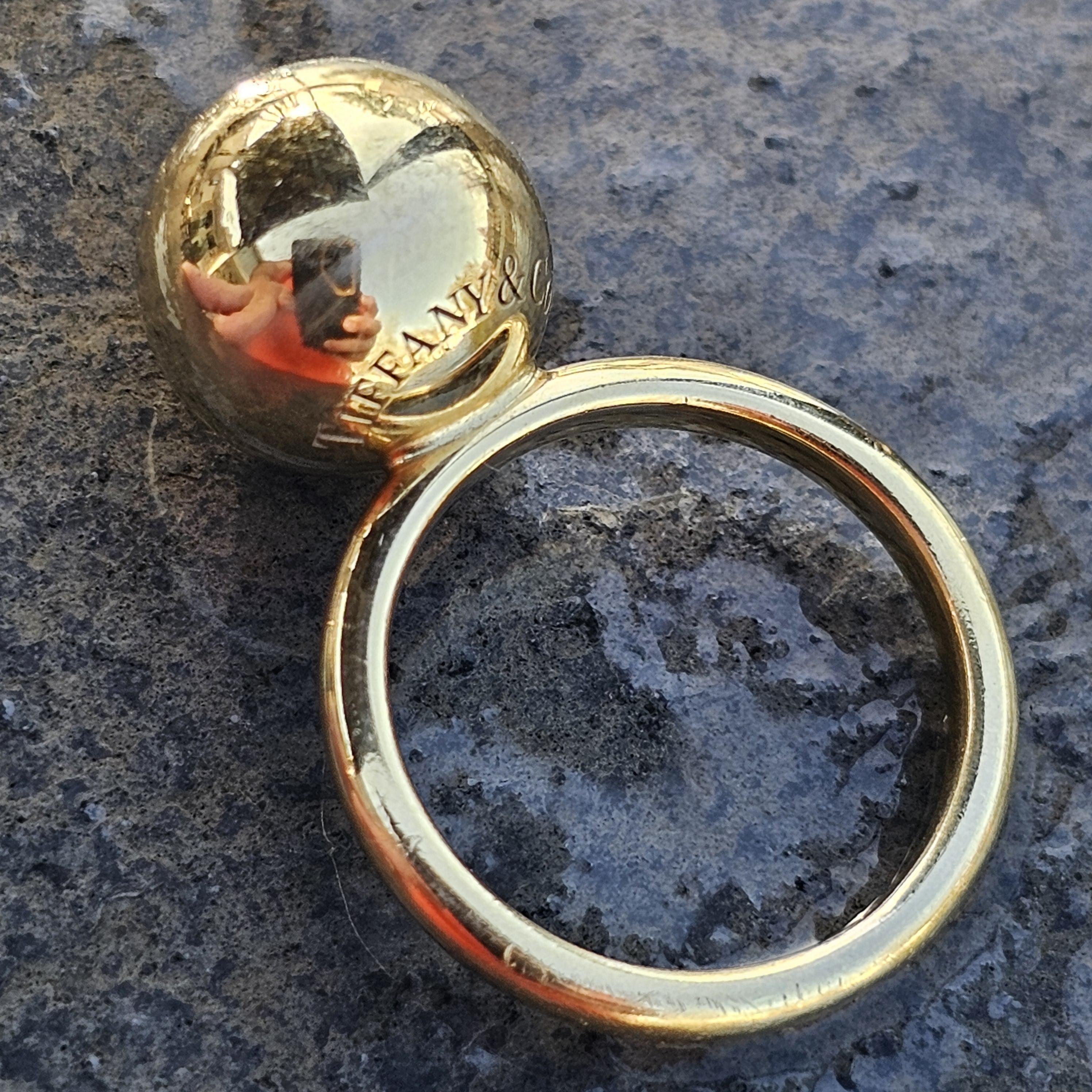 This Tiffany & Co. Hardwear 12mm ball ring is a striking piece of fine jewelry, ideal for any occasion. Crafted from 18k yellow gold, this ring is a size 5.75. The design features a bold, spherical element that adds a modern touch to the classic