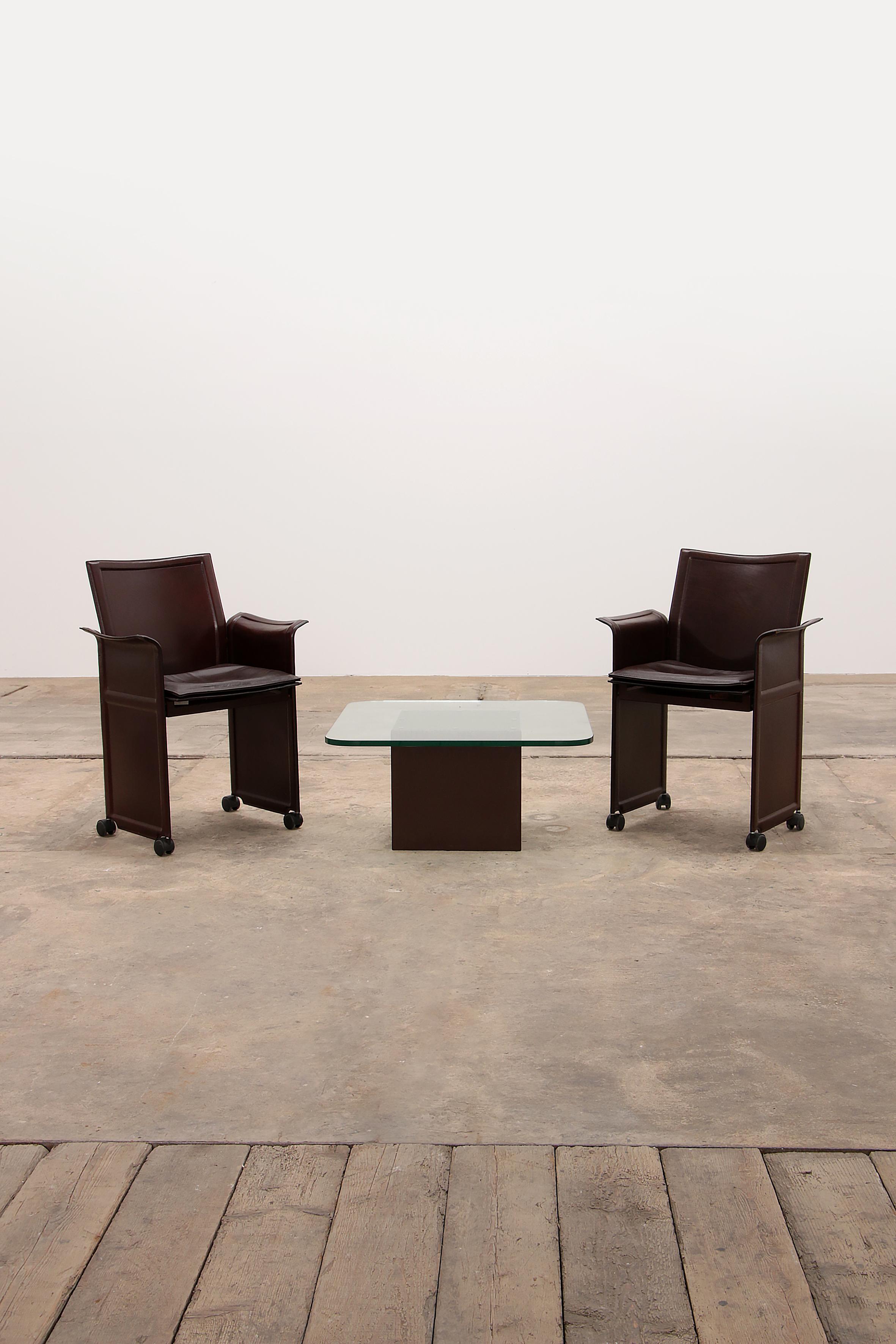 
Modernes Set aus 2 schokoladenbraunen Vintage-Stühlen, entworfen von Tito Agnoli für Matteo Grassi 1979, Italien. Mit einem Couchtisch. Das Besondere an dem Stuhlmodell Korium ist das hochwertige, gesteppte Leder mit einem Metallrahmen. Diese