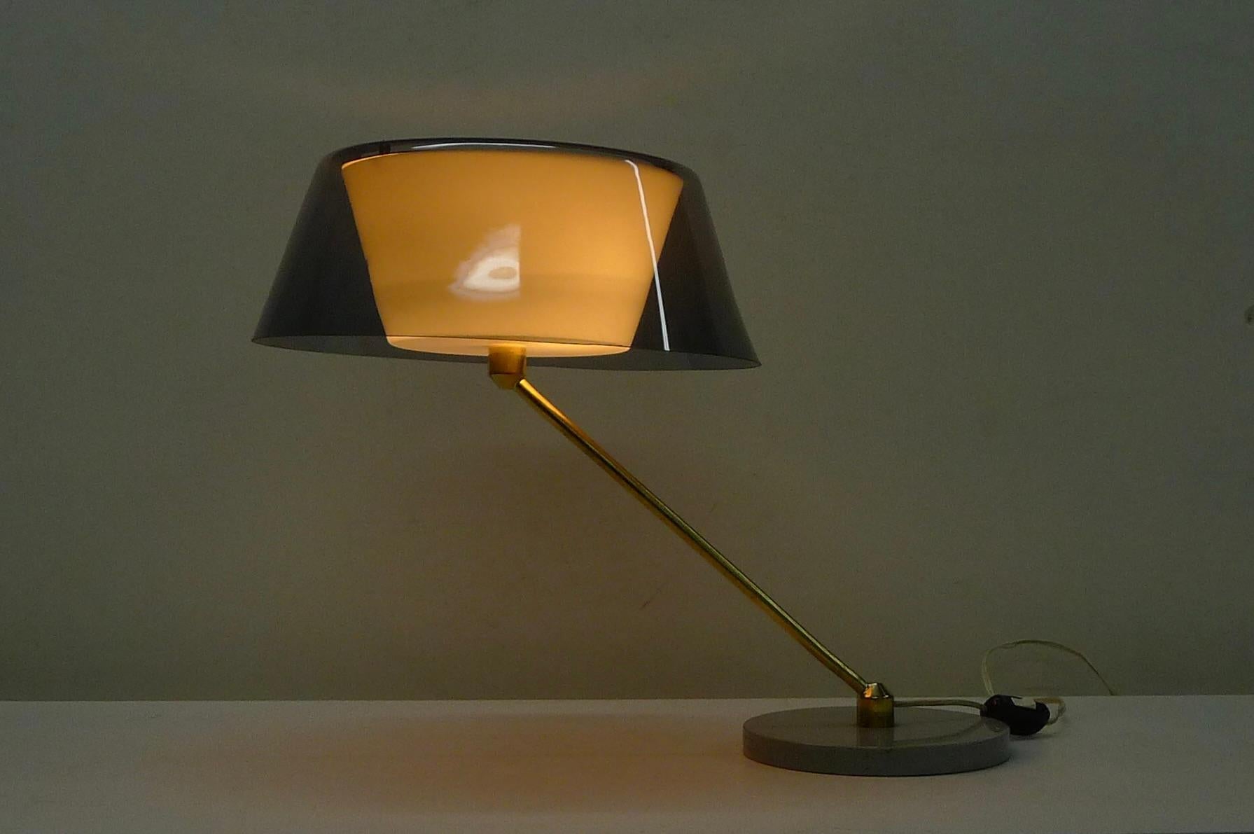 Tito Agnoli, Modello 253, Tischleuchte, entworfen 1958 und hergestellt um 1960 von O'Luce, Italien.  Mit umgedrehten Plexiglasschirmen, der äußere in zartem Violett, der innere in Weiß. 
Der Stiel aus Messing dreht sich auf dem grau emaillierten