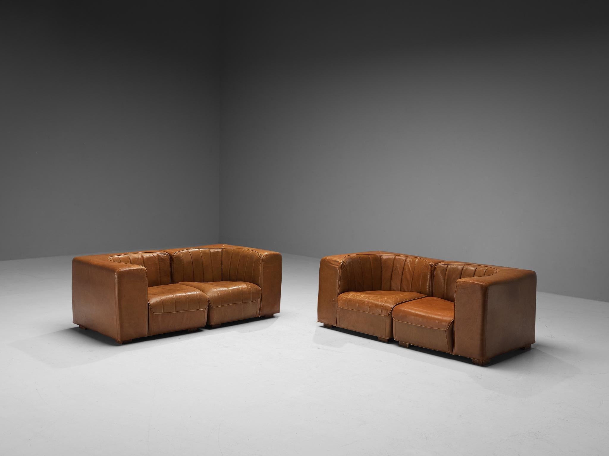Tito Agnoli für Arflex, zweisitzige Sofas, Modell '9000', patiniertes Leder, Holz, Italien, 1969

Dieses Design zeichnet sich durch einen kubischen Außenrahmen aus, der einen optisch interessanten Kontrast zum runden Sitz bildet. Beim Sitzen