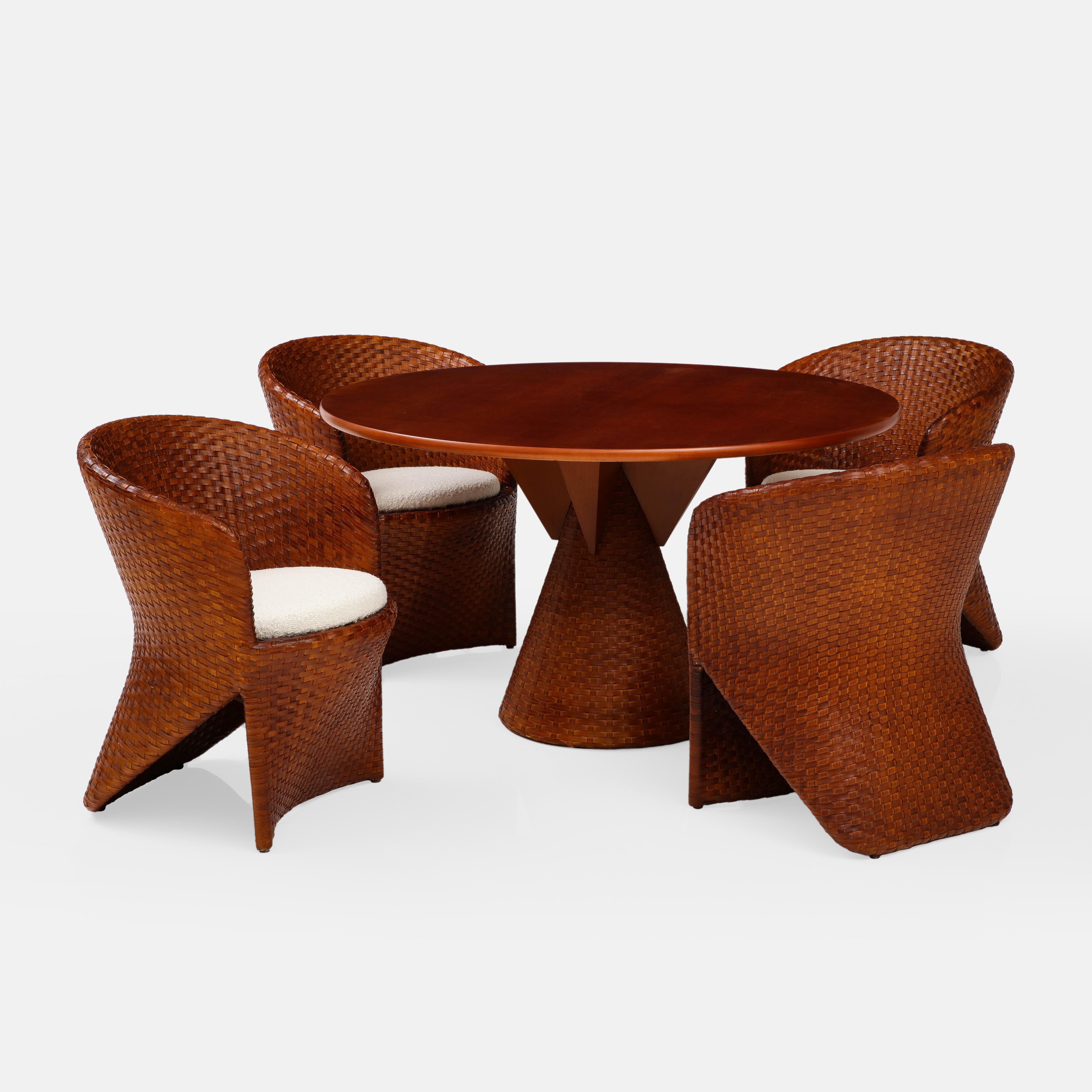 Tito Agnoli for Pierantonio Bonacina rare exquisite Carabou dining set consisting of a round cherry wood and rattan dining table and four woven rattan dining chairs. This architectural dining table has a cherry wood top and a woven rattan conical