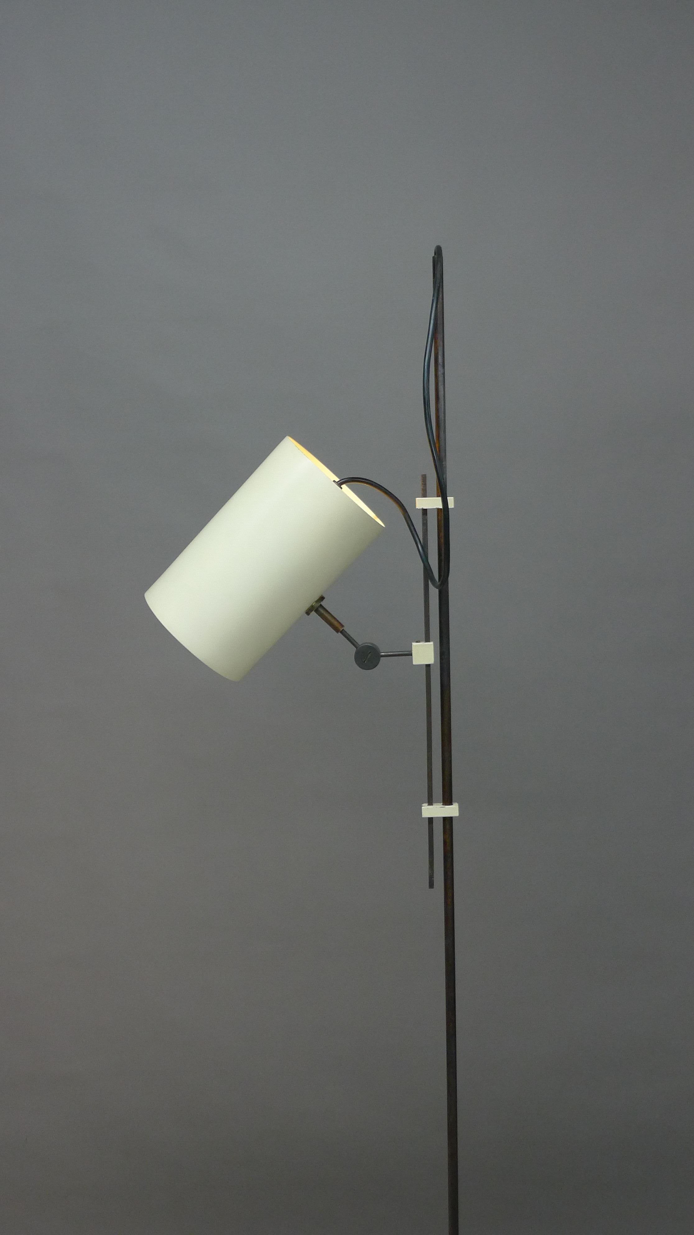 Tito Agnoli for Oluce, Italy, 1954. A model 367 floor lamp, circular white enamelled foot supports the metal stem to which is attached by small white blocks a sliding mechanism with a further white block holding the shade apparatus. This pivots at