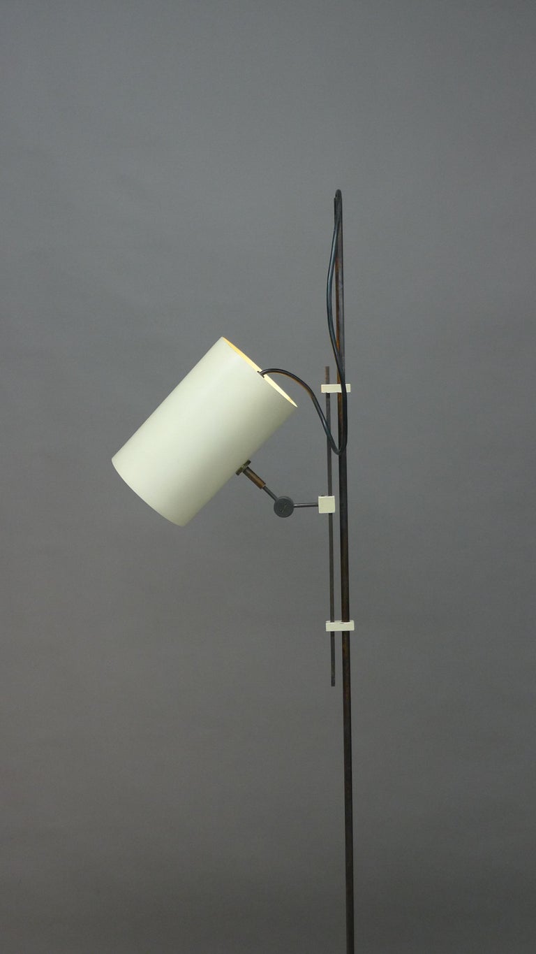 Tito Agnoli for Oluce, Italy, 1954. A model 367 floor lamp, circular white enamelled foot supports the metal stem to which is attached by small white blocks a sliding mechanism with a further white block holding the shade apparatus. This pivots at