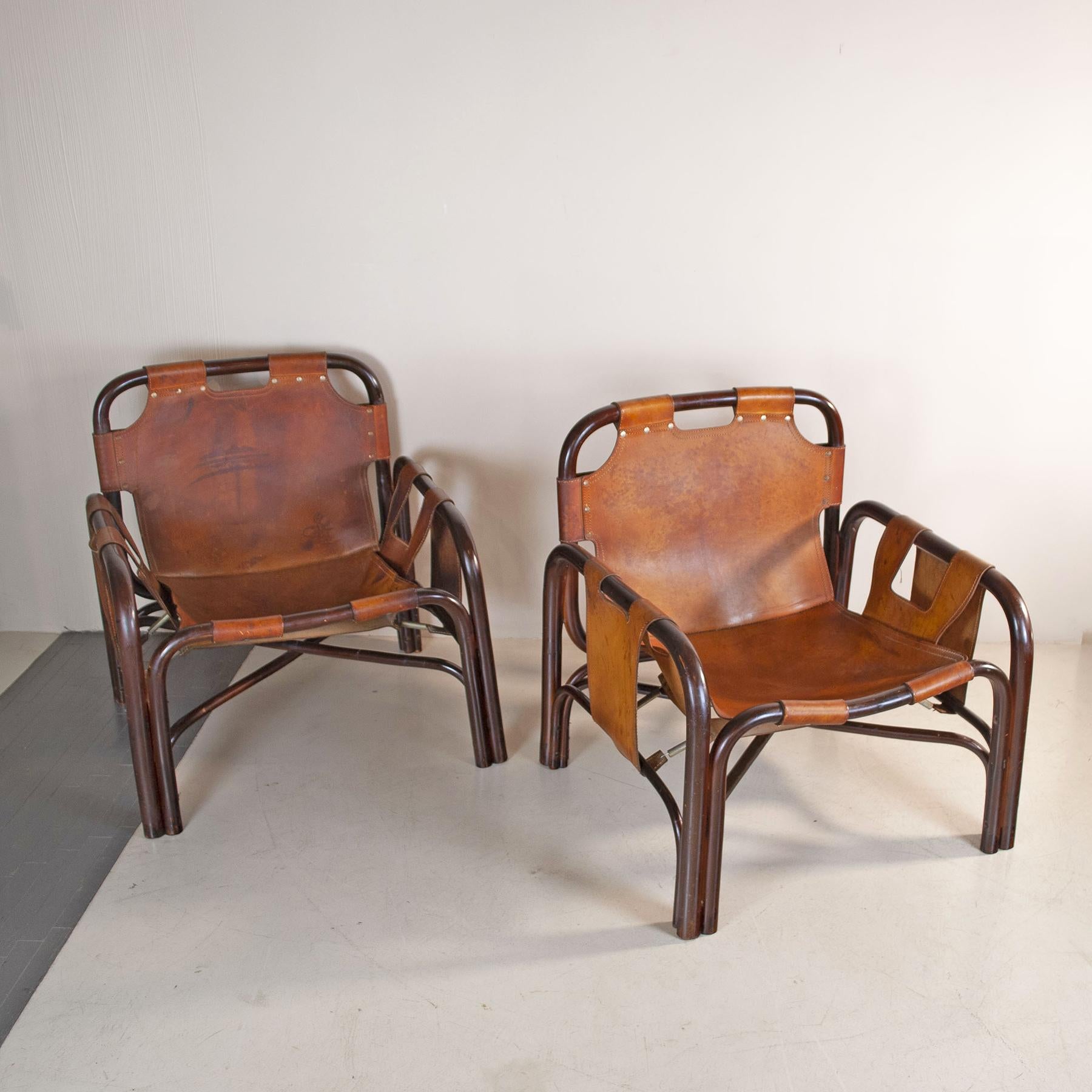Ensemble de deux fauteuils conçus par Tito Agnoli pour Bonacina à la fin des années 1960. Structure en bambou et revêtement en cuir naturel de couleur cognac. Quelques taches sur le cuir