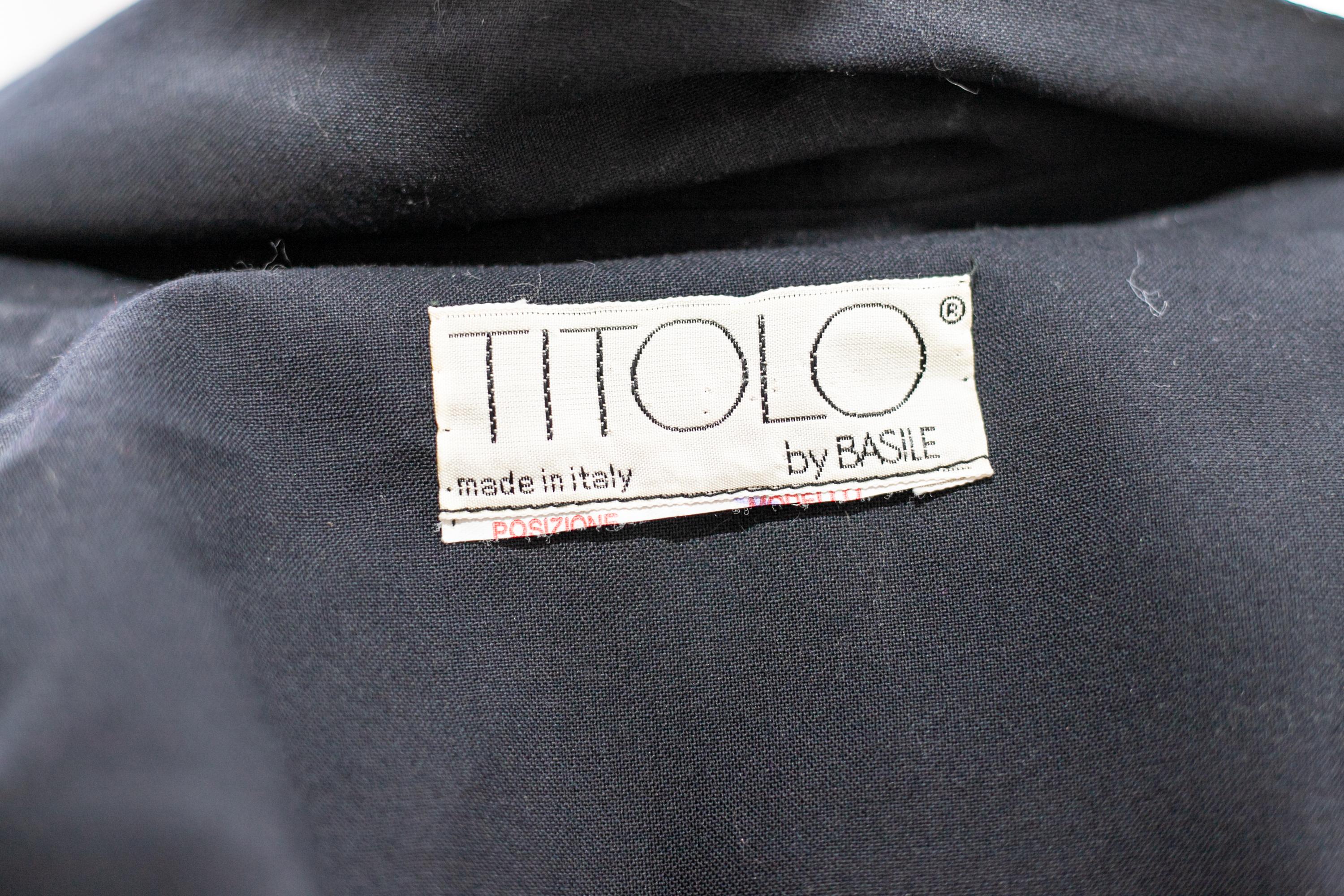 Lovely vintage trench coat designed by Titolo for Basile in the 1990s, made in Italy.
ORIGINAL LABEL.
The blazer is totally made of black cotton with long but soft sleeves.
The collar has a classic standard stand-up cut, which gives an unparalleled