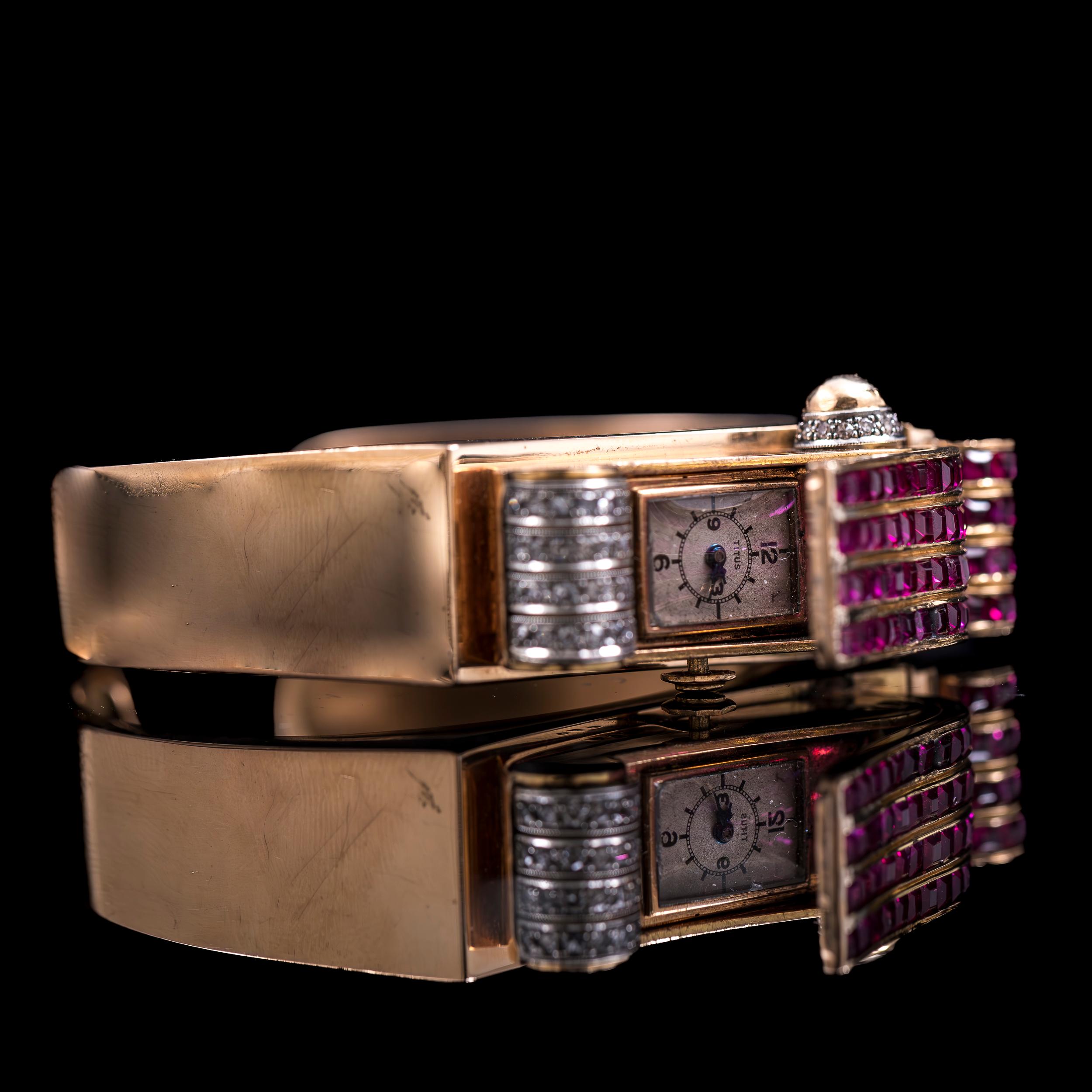 Art Deco diamond and synthetic ruby odeonesque concealed bracelet and cocktail watch in 19.2kt yellow gold and platinum, signed Titus, Portugal, 1940s. This exquisite piece boasts a dual identity, seamlessly merging the allure of fine jewelry with