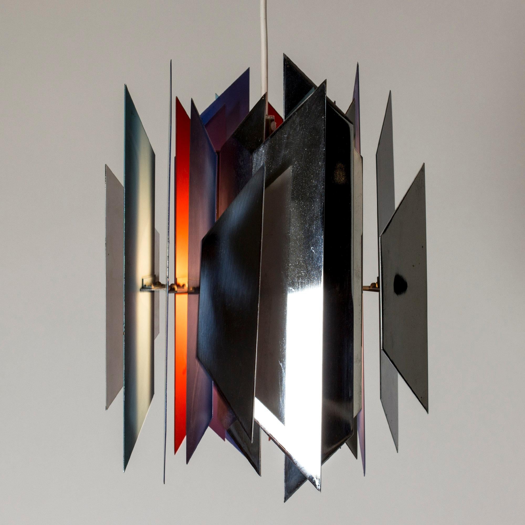 Striking “Tivoli” ceiling lamp by Simon Henningsen. Made from metal with inside painted different colors that together with how the light falls and reflects create a very cool visual effect.