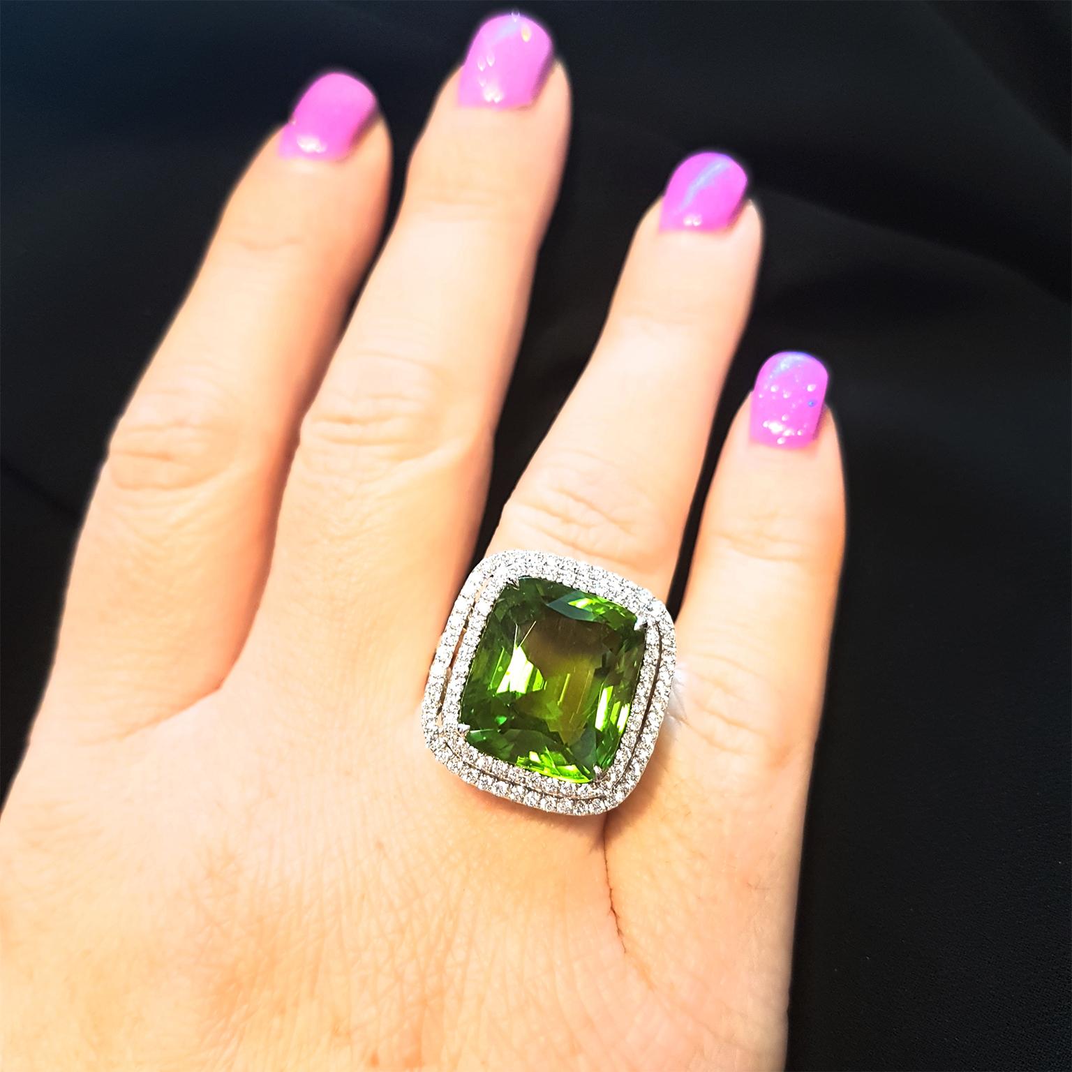 PURE PERIDOT! This magnificent cocktail ring has been crafted in 18ct Yellow & White Gold and set with a double-halo of 1.25ct glittering fine white diamonds & a captivating 18.12ct vivid Peridot. One-off & Exclusive!