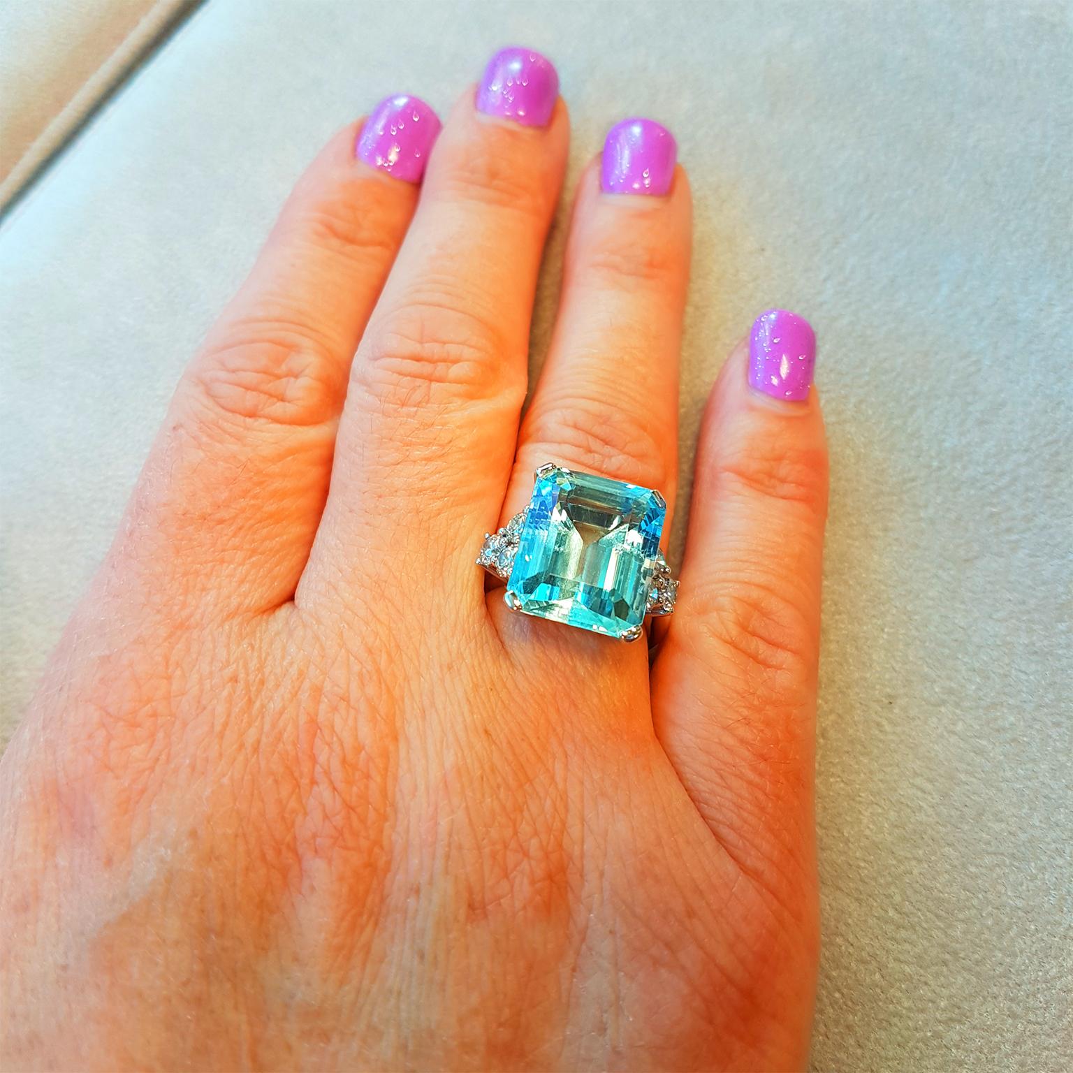 BRAZILIAN BLUE! This magnificent classic cocktail ring has been crafted in 18ct White Gold and set with a trefoil of over a carat of glittering fine white diamonds on each side of a gorgeous emerald-cut Brazilian, sea-water blue Aquamarine 12.55ct.