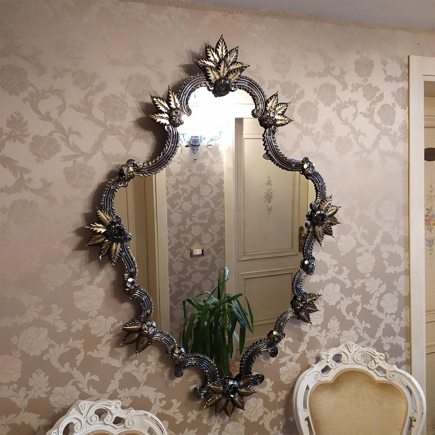 Exuding an opulent and dramatic allure, this wall mirror will make a singular and refined addition to an eclectic modern interior. A superb embodiment of the Venetian style and the valuable, long-lasting tradition of glassmaking, it is handmade of