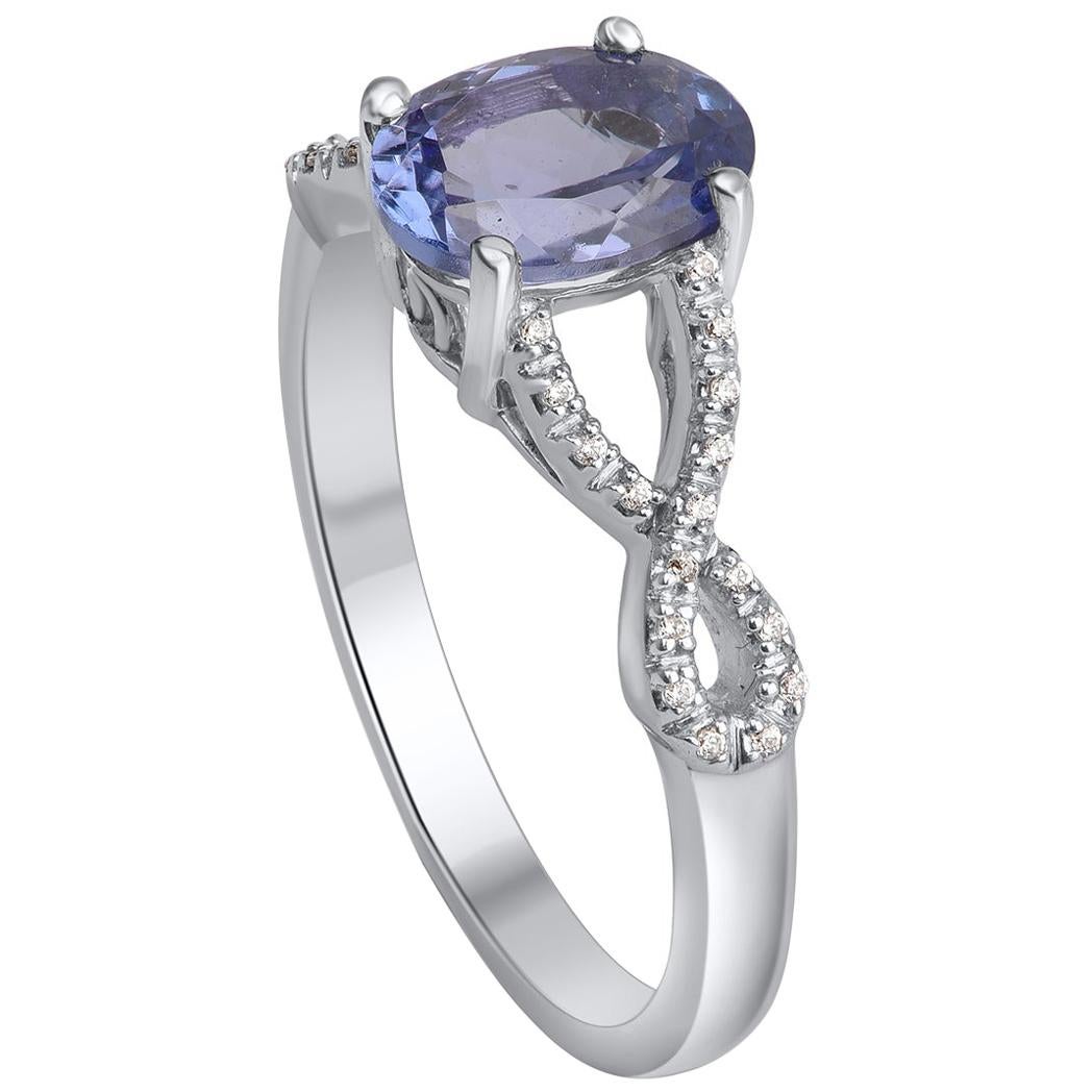 Elegantly designed by our skillful artisans in 14 KT white gold and studded with 34 brilliant diamonds and 1 tanzanite in prong setting. Diamonds are graded in HI color and I2 clarity. This split shank designer diamond engagement ring is truly
