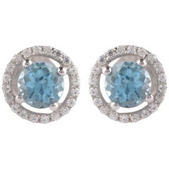 Boucles d'oreilles en or blanc 18 carats avec halo de diamants 0,10 ct. pt. et 4 mm de topaze bleue suisse ronde TJD