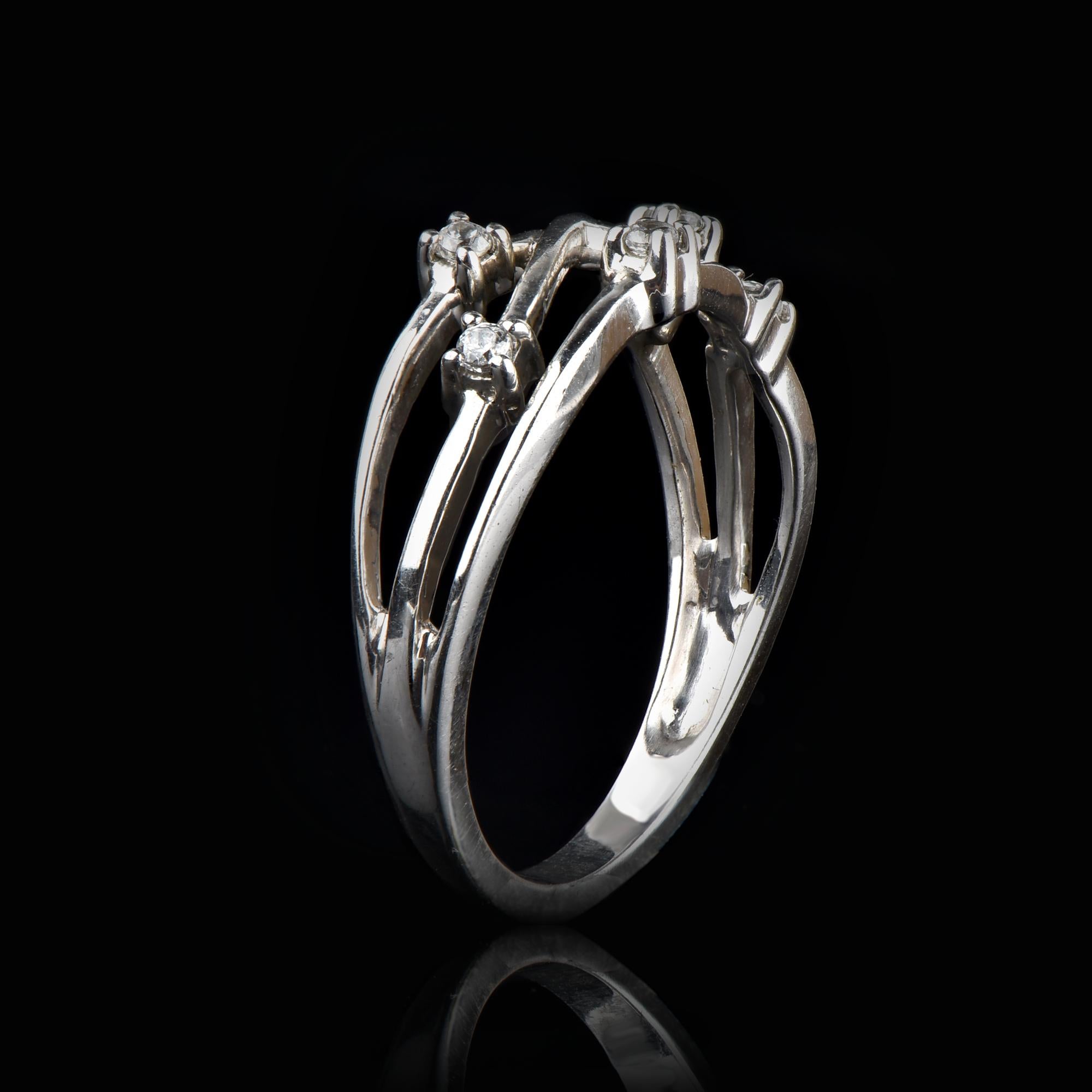Exquisite 14K white gold crisscross wedding band ring featuring 6 round-cut white diamonds. This ring is superbly detailed to perfection and set with 0.12 carat of sparkling brilliant cut round diamonds in secured prong setting. The diamonds are