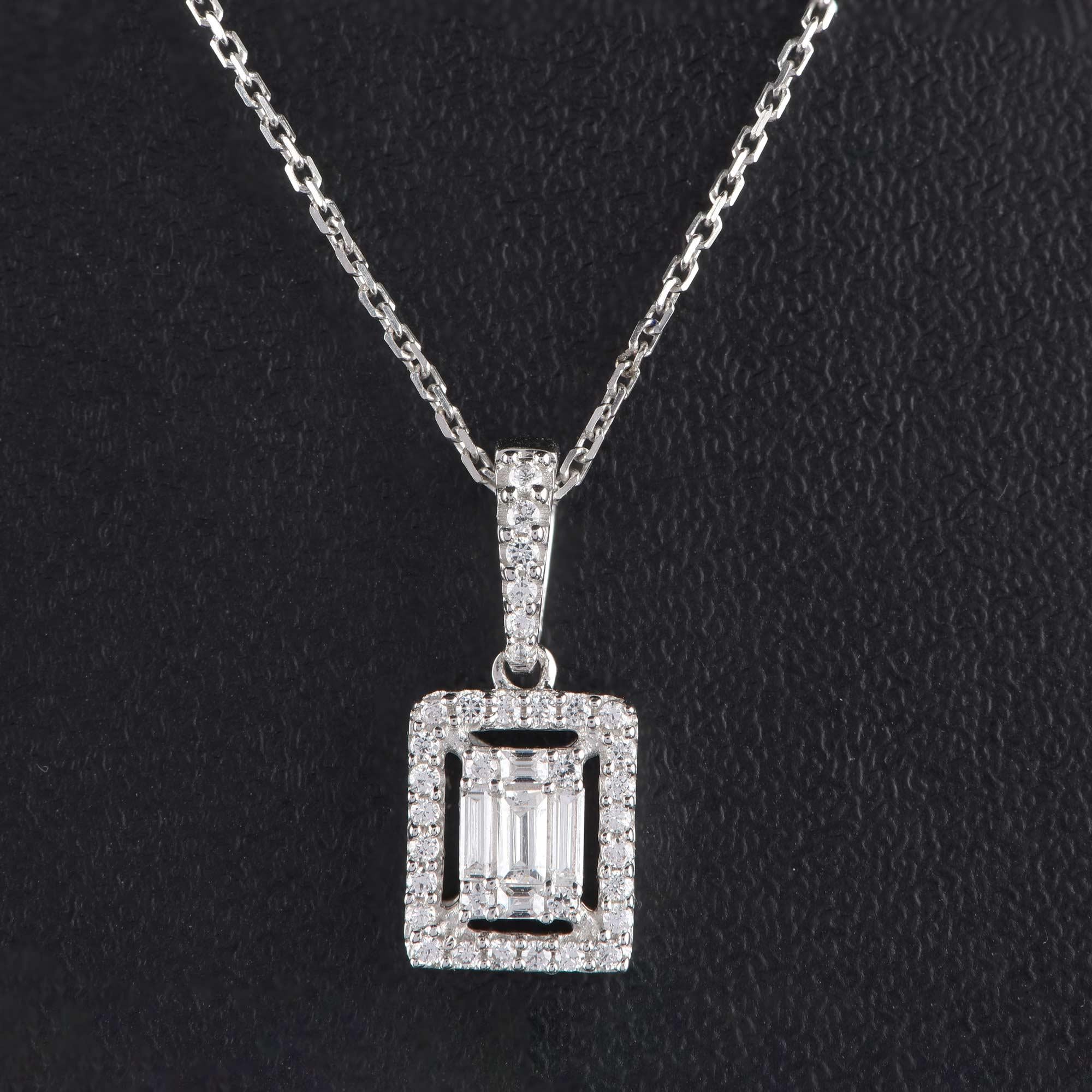 Crafted in 18-karat white gold and embedded with 34 brilliant cut and 5 baguette shape diamonds in prong setting. Diamonds are graded H-I Color, I2 Clarity. The pendant comes along with an 18 inch cable chain.

