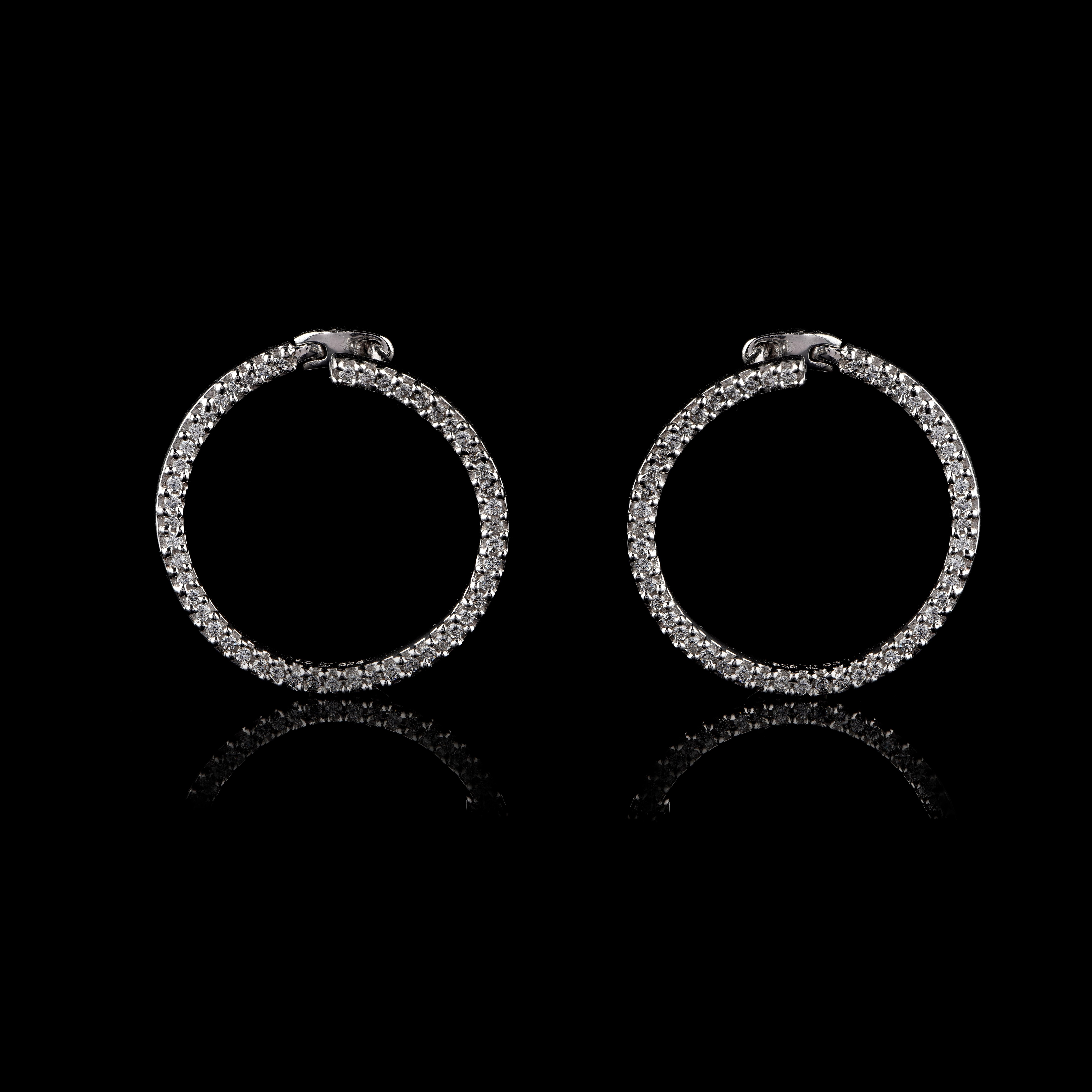 These circular earrings are studded with 100 brilliant cut diamonds in prong setting. Intricately hand-crafted by our in-house experts in 18 KT white gold. The diamonds are graded H-I Color, I2 Clarity.