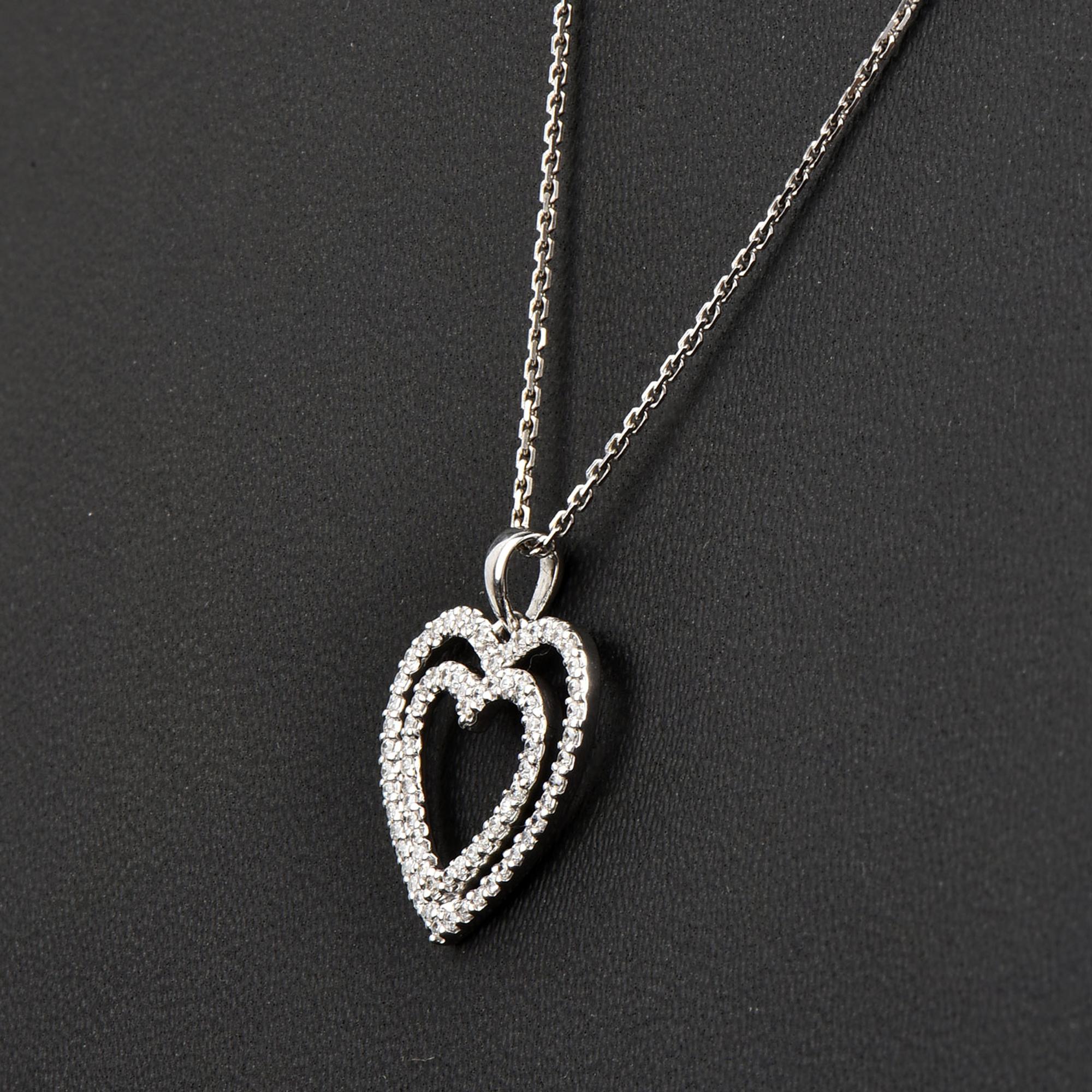 Bring charm to your look with this diamond double heart pendant. The pendant is crafted from 14-karat White gold and features Round Brilliant 77 white diamonds set in prong setting H-I color I2 clarity and a high polish finish complete the Brilliant