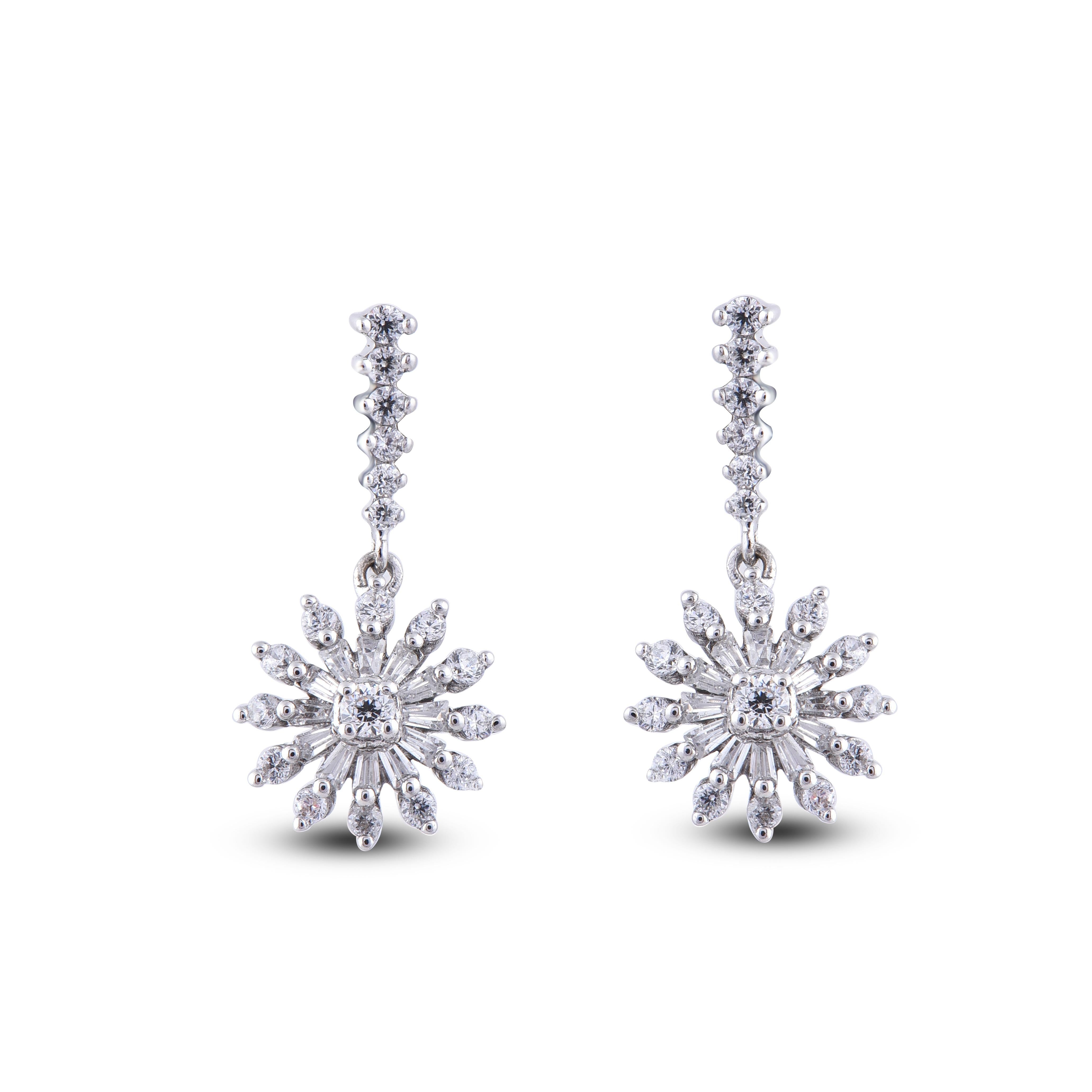 Ces boucles d'oreilles pendantes florales en diamant au design exquis offrent une beauté qui n'a d'égale que la sienne. Ces boucles d'oreilles présentent 38 diamants ronds et 24 diamants baguettes en or blanc 14 carats, montés en serti clos. Ces